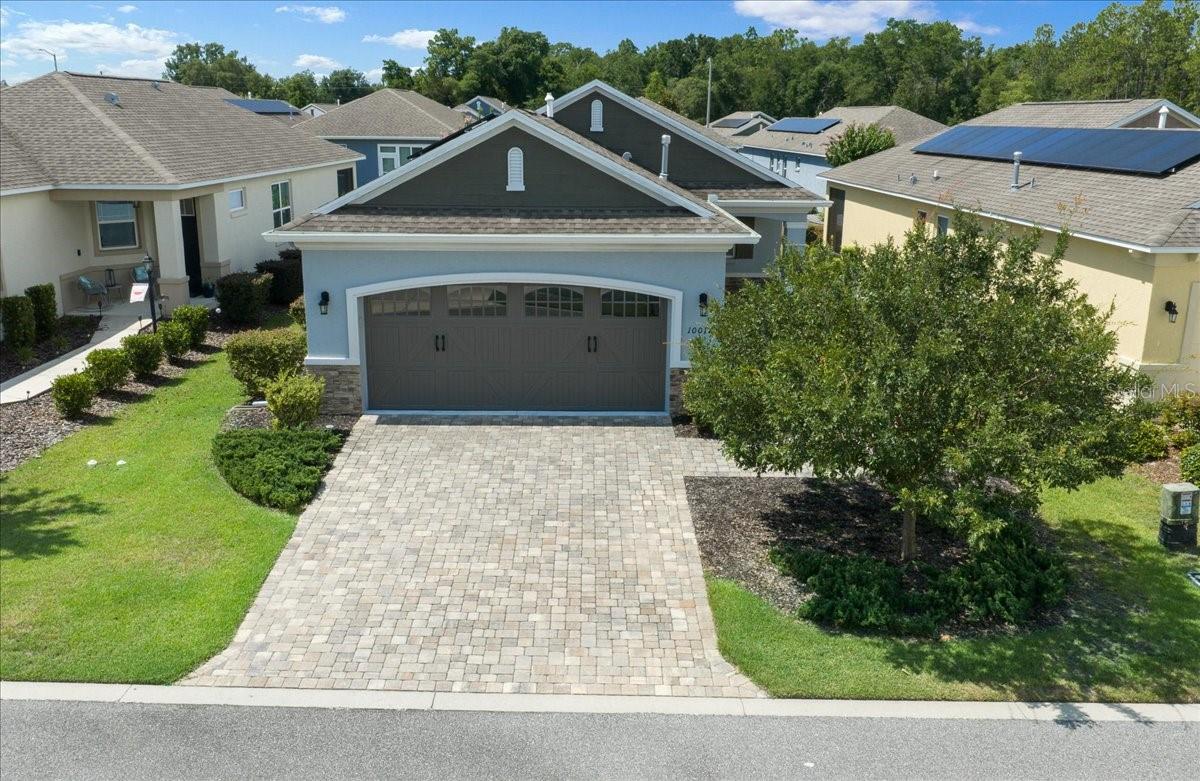 Experience the best of Florida's active adult lifestyle in this highly sought-after Tamar Model SMART Home, featuring fully paid and transferable SOLAR panels, located in the desirable Crescent Ridge 3 neighborhood of On Top of the World. Combining energy efficiency, modern technology, and stylish upgrades, this move-in-ready home offers everything today's discerning buyer is looking for. The home's attractive curb appeal begins with stacked stone accent, a paver driveway and walkway leading to a stunning full-panel beveled glass entry door. Step inside and immediately appreciate the light-filled, open floor plan designed for comfortable everyday living and effortless entertaining. Just off the foyer, elegant frosted French doors open to a spacious Flex Room—perfect for a home office, hobby room, library, or additional guest space. Guests will appreciate the private bedroom and nearby full bath, while the dedicated laundry room and two-car garage provide convenience and functionality. Plantation shutters, crown molding, and 18” on diagonal tile floors (except in bedrooms) add timeless charm and create the perfect Florida ambiance. At the heart of the home is the impressive Gourmet Kitchen, thoughtfully designed for both cooking and entertaining. Features include upgraded gray cabinetry, granite countertops, custom backsplash, stainless steel appliances, natural gas range, large center island with seating, double-door pantry, and a window over the sink that fills the space with natural light. The open-concept Great Room and dining area create a welcoming gathering space and seamlessly connect to the screened lanai, making indoor-outdoor living a breeze. The private owner's suite is tucked away at the rear of the home and features a spacious walk-in closet and an ensuite bath with dual vanities and an upgraded step-in/roll-in tiled shower designed for convenience and accessibility. Step outside to the screened lanai and enjoy your morning coffee, evening cocktail, or simply relax while taking in the peaceful surroundings. The home's abundance of windows creates a bright, cheerful atmosphere throughout. Adding exceptional value are the fully paid and transferable solar panels, helping keep utility costs low, along with natural gas service for cooking and other household needs. Simply unpack and start enjoying the resort-style amenities, clubs, golf, fitness centers, pools, and active social lifestyle that make On Top of the World one of Ocala's premier 55+ communities. This exceptional home truly offers the perfect combination of comfort, efficiency, style, and carefree living. Schedule your private showing today! The monthly HOA fee includes DCM Basic Internet, roof repair, exterior painting every seven years, exterior maintenance and insurance, landscaping, curbside mail delivery, curbside trash & recycling pickup, 24/7 monitored gates and all the amenities that OTOW has to offer; four pools, two state of the art fitness centers, pickleball (both covered and open), billiards, archery range, corn hole, bocce ball, tennis, shuffleboard, horse shoes, remote control flying field and race cars, 175+ clubs, woodworking shop (extra fee), library, and much, much more! A golf cart community with access to several shopping centers.