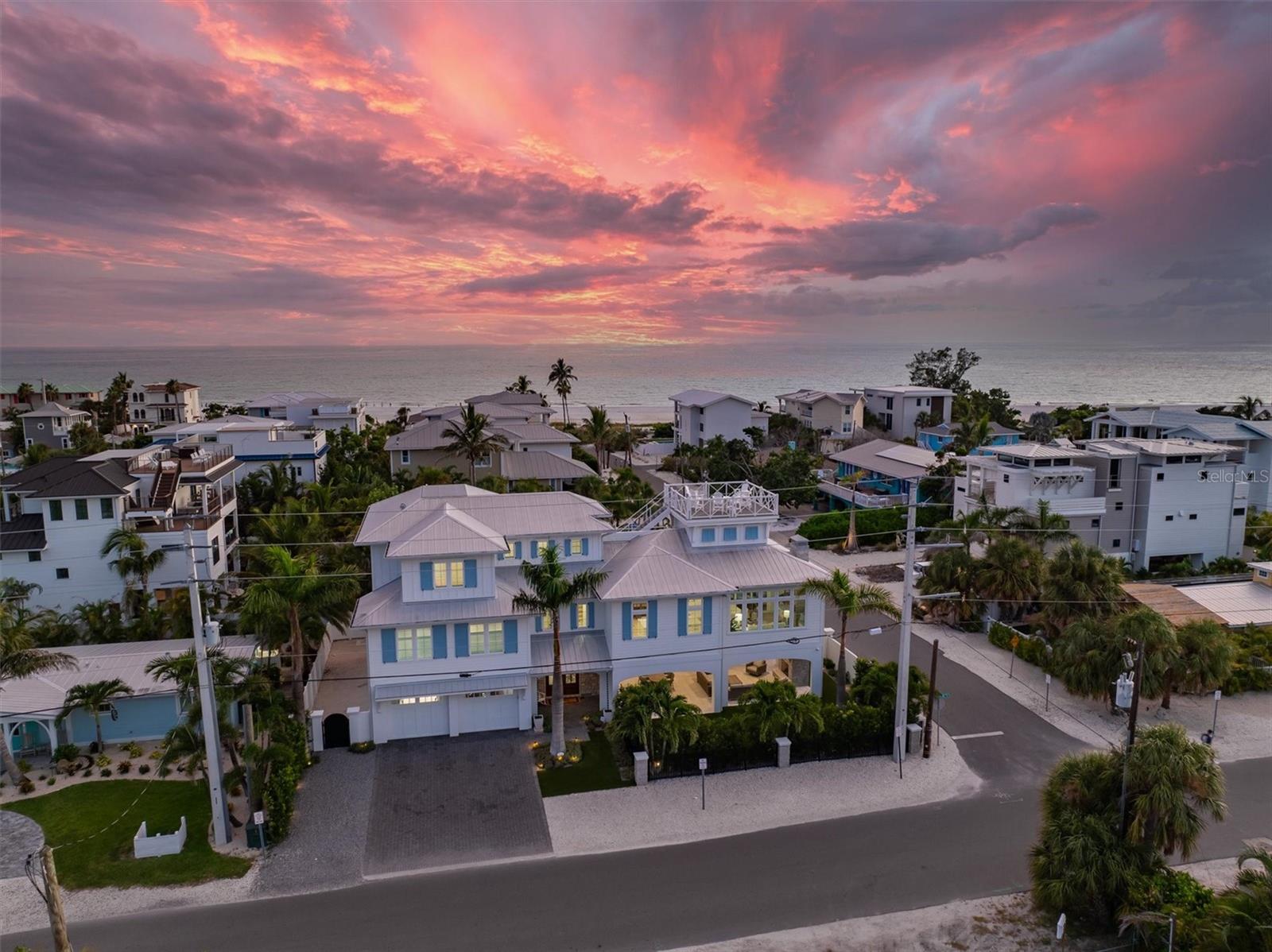 Discover unparalleled elegance in this stunning 3,400 sq. ft. very private residence 5 houses away from the Gulf on the north end of Anna Maria Island!   You get to enjoy beach views from many rooms in the house without the beachfront price!  Very well taken care of, never rented, and hurricane-rated elevated home that stands at one of the island’s highest elevation points.  Built with a robust 25’ deep drilled piling foundation system, this architectural masterpiece combines cutting-edge smart home technology with timeless luxury.  Five generously sized bedrooms, each with en-suite full bathrooms, plus two half baths (one conveniently located off the pool area). The master suite boasts a marble-clad bathroom with a luxurious shower, floors, and countertops, while other bathrooms feature sleek quartz countertops.  The chef’s kitchen is equipped with Sub-Zero and Wolf appliances, including a 36” refrigerator, 30” freezer, wine refrigerator, under-counter refrigerator, and pantry refrigerator/freezer drawers. The 48” dual-fuel gas/electric stove with four burners and a 24” griddle, paired with a convection/steam oven, ensures culinary excellence. Custom Campbell Cabinetry, dolomite marble countertops with a leathered finish, and an instant hot/cold filtered water system elevate the experience.  Control your environment with ease using the Blue Sound eight-zone interior/exterior audio system, Leviton smart lighting, Honeywell alarm system, IC Realtime 9-camera system, and remote keypad door locks and garage door openers with battery backup.  Motorized Hunter Douglas roller shades grace the living, dining, and kitchen areas, while a Leon Speaker Framed Art Concealed Television and Sound System adds a touch of modern artistry.   Engineered French Oak hardwood flooring flows throughout, complemented by tongue-and-groove wood ceilings, shiplap wall cladding, and natural stone gas fireplaces in the living room and pool area. Hardiboard cement board siding, Azek trim, and a custom six-foot stucco perimeter wall with powder-coated aluminum privacy gates ensure durability and privacy.  Talk about a Resort-Style Outdoor Oasis!   Dive into the 14’ x 32’ custom  saltwater pool for complete relaxation.  There is a gas spa to heat up quickly and an electric pool heater.  The LED lighting and water features at night is such a fun touch!   Completed with turf for very low maintenance clean up.  Shower off in the custom outdoor enclosed shower after beaching it then head up to the spacious roof top deck that has panoramic views of the Gulf and even the skyway bridge!!  Elevator, climate controlled garage, sunroom are some more bonuses!  This home truly has it all!   Such a rare opportunity to own a private, high-elevation sanctuary on Anna Maria Island, blending state-of-the-art technology with coastal charm. This luxurious, comfortable, storm-resistant home is ready for you to move right in!