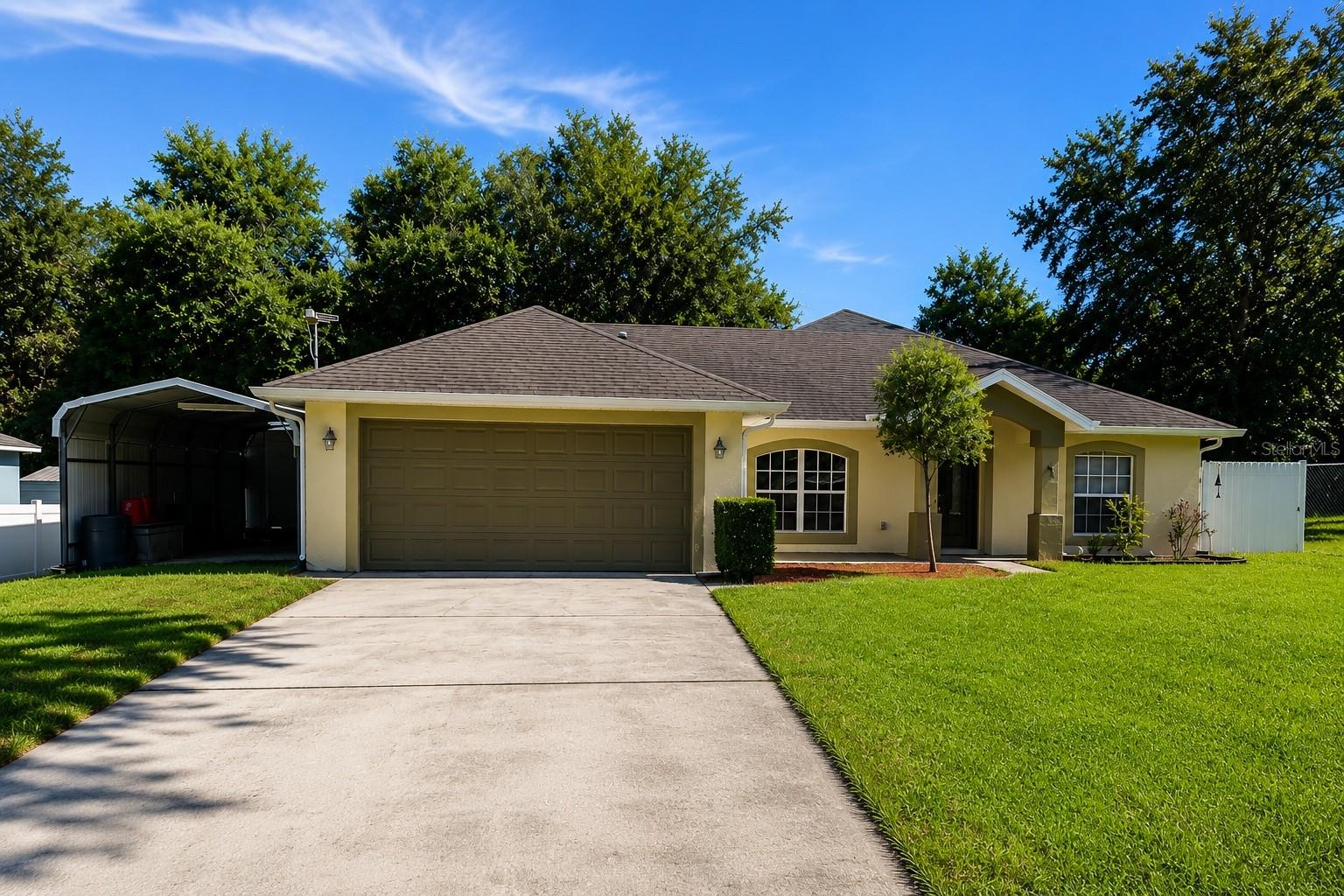 Country Living with Modern Convenience – NO HOA!

Welcome to this spacious 4-bedroom, 2-bath home offering the perfect blend of peaceful country living and everyday convenience. Situated on a quiet private dead-end street with very little traffic, you'll enjoy privacy while remaining just moments from shopping, dining, and major roadways. Just half a block away, you'll find access to the Cross Volusia Trail and nearby state park land, making it easy to enjoy walking, biking, and Florida's natural beauty.

Inside, you'll find beautiful 24" x 24" porcelain tile flooring throughout, helping keep the home cool while providing a clean, modern look. Originally built as a 3-bedroom, 2-bath home, a 2018 addition expanded the living space to create a true 4-bedroom, 2-bath layout, providing extra room for family, guests, or a home office. Approximately half of the roof was also replaced during the 2018 addition.
Outside is where this property truly shines! In addition to the attached 2-car garage, you'll find an impressive 11' x 25' metal carport—ideal for an RV, boat, additional vehicles, or recreational equipment. The detached 10' x 14' climate-controlled metal building is perfect as a workshop, hobby room, home office, fitness room, or extra storage.

The backyard is fully enclosed with a durable Miami-style metal fence, a premium feature rarely found in this area. For added peace of mind, the home is also equipped with generator connections already installed, making storm preparation quick and convenient.

Enjoy the benefits of private well and septic with no water bill, and best of all—NO HOA! Bring your boat, RV, work truck, or recreational vehicles without the restrictions often found in many communities.

Conveniently located just minutes from Downtown Orange City, Downtown DeLand, schools, shopping, restaurants, Publix, US 17-92, and Blue Spring State Park, this home offers the perfect balance of privacy, space, and convenience.

If you've been searching for a move-in-ready home with unique features, extra storage, room for all your toys, and a peaceful setting, this one deserves a spot at the top of your showing list!
