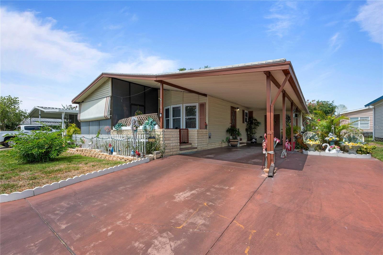 If sunny Florida living is calling your name, this beautifully renovated 2-bedroom, 2-bath home on a premium lot near the community pool is one you won't want to miss. Featuring stylish upgrades throughout and a thoughtfully designed floor plan, this home offers the perfect blend of comfort, functionality, and modern appeal for buyers of all ages. From the moment you arrive, you'll appreciate the double driveway, covered patio, and attractive vinyl siding. Step inside to discover an open and airy floor plan enhanced by luxury vinyl plank flooring and a bright, contemporary kitchen that truly shines. The kitchen features white cabinetry, abundant storage space, electric appliances, a ceiling fan, and a convenient closet pantry. The spacious living room boasts vaulted ceilings and easily accommodates a large sectional or multiple seating arrangements, creating an inviting space for relaxing or entertaining. Adjacent to the kitchen, the dining area offers plenty of room for a larger table, making gatherings with family and friends effortless. The private primary suite is located at the rear of the home and offers ample space for a king-size bed, along with a generous walk-in closet. The ensuite bathroom is beautifully updated with a stylish gray vanity and a walk-in shower featuring frosted glass doors. Situated on the opposite side of the home for added privacy, the guest bedroom and full bath provide a comfortable retreat for visitors. The guest bedroom is tastefully painted and spacious enough to accommodate a queen-size bed. Additional interior features include updated light fixtures, new double-pane tilt-in windows with blinds, and a convenient laundry room located off the carport. Step outside and enjoy Florida living year-round in the oversized Florida room, the perfect place to enjoy your morning coffee or relax with evening breezes. Major improvements include a 2018 air conditioning system, a new 2026 membrane roof, and an attached 11' x 18' storage room that provides plenty of space for tools, hobbies, and extra storage. Located in Timber Lake Estates, a gated, non-age-restricted community, residents enjoy an active and welcoming lifestyle with two resort-style swimming pools, a hot tub, fishing pier, and a vibrant clubhouse complete with a library and billiards room. Conveniently situated near the expanded Wiregrass Town Center, shopping, dining, grocery stores, and with easy access to I-75, this location offers exceptional convenience. The low monthly fee of just $217 includes water, sewer, trash removal, lawn care, and full access to all community amenities. Golf-cart friendly and thoughtfully designed, Timber Lake Estates also offers RV and boat parking/storage for a nominal fee, making it an ideal community for those who enjoy both relaxation and adventure. 3145 Great Oak is move-in ready, thoughtfully updated, and being offered semi-furnished. Schedule your private showing today and start enjoying the Florida lifestyle you've been dreaming of!