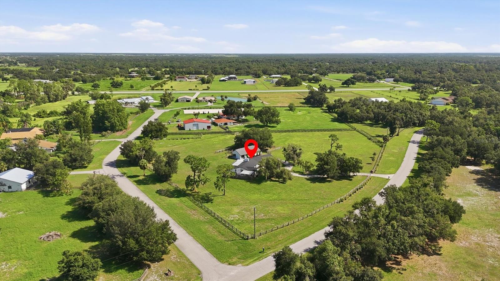 Don't miss this exceptionally rare opportunity to own 5 sprawling acres in the private airport community of Hidden River! This 3-bedroom, 2-bath property offers the space, freedom, and versatility to bring your vision to life, whether that includes horses, aviation, future expansion, or simply enjoying the privacy that only acreage can provide. Already in place are a NEW ROOF (2025), NEW water heater (2025), whole-house water softening and filtration system, established equestrian amenities, and water and electric extended into the property for future expansion. Inside, the living room is centered around a fireplace and framed by sweeping views of the property beyond. Currently set as a formal dining room, the adjoining flex room provides exceptional versatility as an additional sitting area, game room, or library. The kitchen is beautifully equipped with granite countertops, stainless steel appliances, prep island, a spacious dinette, and generous cabinetry. Nearby, an additional room is enhanced by built-in shelving and a built-in desk, making the perfect space for a home office or playroom. Privately positioned, the primary suite offers a spacious bedroom, walk-in closet, and en suite bathroom with dual vanities and a separate shower. A fenced private courtyard with an outdoor shower extends the primary suite outside, offering room to lounge, dine, tend a garden, create a private fitness space, or simply enjoy the peace and privacy of the surrounding property. Two additional bedrooms and a full bathroom offer comfortable space for guests. Beyond the home, the five-acre setting reveals even more to discover. The horse barn features two stalls, a tack room, and dedicated mower and golf cart storage, while a Nelson automatic horse watering system adds even more convenience for horse owners. A large separately fenced chicken coop expands the property's homesteading appeal, while the fenced play area and fire pit create inviting spaces to gather and enjoy the outdoors. Water and electric have already been extended into the field, providing an outstanding head start for a future workshop or ADU. For aviation enthusiasts, Hidden River offers the opportunity to fly where you live. Residents enjoy access to the community's private 2,640-foot paved and lighted runway, creating a one-of-a-kind setting for pilots and aircraft owners alike. This exceptional estate is located on the high and dry side of the community, well outside of the flood zone. From the thoughtfully designed home to the expansive acreage, established equestrian amenities, future expansion potential, and private airport access, every element of this property comes together to create an extraordinary place to call home.