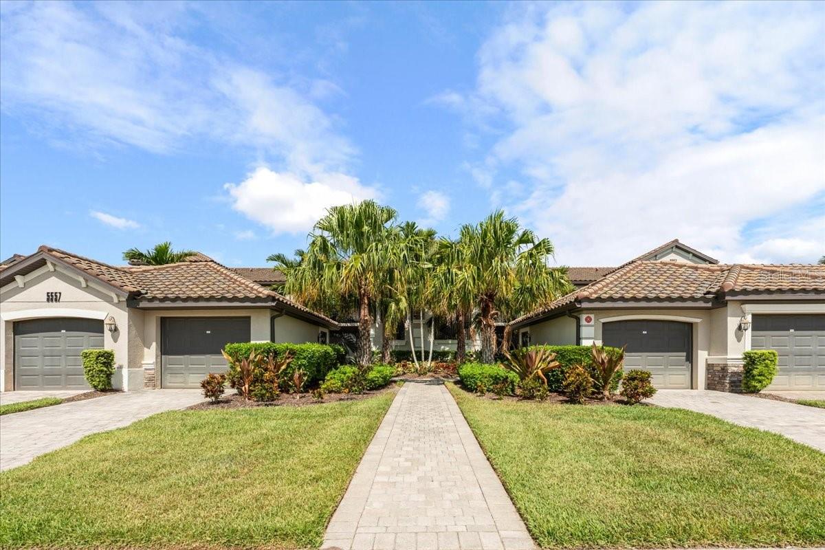 Welcome to resort-style living in the highly sought-after Lakewood National Golf Club, where luxury, comfort, and breathtaking views come together in this beautifully furnished 2-bedroom, 2-bathroom condo with a versatile den. Offered turnkey furnished, this impeccably maintained residence is truly move-in ready—just bring your golf clubs and swimsuits and start enjoying the Florida lifestyle. From the moment you step inside, you'll appreciate the soaring ceilings, abundant natural light, and spectacular golf course views that create an inviting and relaxing atmosphere. The open-concept floor plan is perfect for everyday living and entertaining, seamlessly connecting the spacious living area, dining space, and well-appointed kitchen featuring stainless steel appliances, breakfast bar seating, and everything needed for the home chef. The spacious primary suite offers a king-size bed, dual walk-in closets, and a luxurious en-suite bathroom complete with dual vanities and a large walk-in tiled shower. Guests will feel right at home in the comfortably furnished second bedroom with a queen bed, while the den provides additional flexibility with a daybed and trundle—ideal for extra guests, a home office, or a cozy reading retreat. Enjoy the best of indoor-outdoor living with screened lanais at both the front and rear of the condo. Start your mornings with coffee overlooking the course and end your evenings taking in spectacular Florida sunsets with panoramic views of Hole #1 on The Commander Course, one of two championship Arnold Palmer-designed golf courses. Additional features include an in-unit washer and dryer, a detached one-car garage with extra storage, plus bicycles, beach chairs, tennis racquets, and pickleball paddles—all included for the next owner to enjoy from day one. As a resident of Lakewood National Golf Club, you'll have access to an unmatched collection of world-class amenities, including 36 holes of championship golf, a stunning 28,000-square-foot clubhouse with fine dining and bar, resort-style pool with tiki bar, full-service spa, state-of-the-art fitness center, eight Har-Tru tennis courts, pickleball courts, bocce ball, a full-time lifestyle director, and an active calendar of social events. Ideally located just minutes from Lakewood Ranch, UTC shopping and dining, Gulf Coast beaches, SR-70, and I-75, this exceptional home offers the perfect combination of luxury, convenience, and the ultimate Florida golf lifestyle.