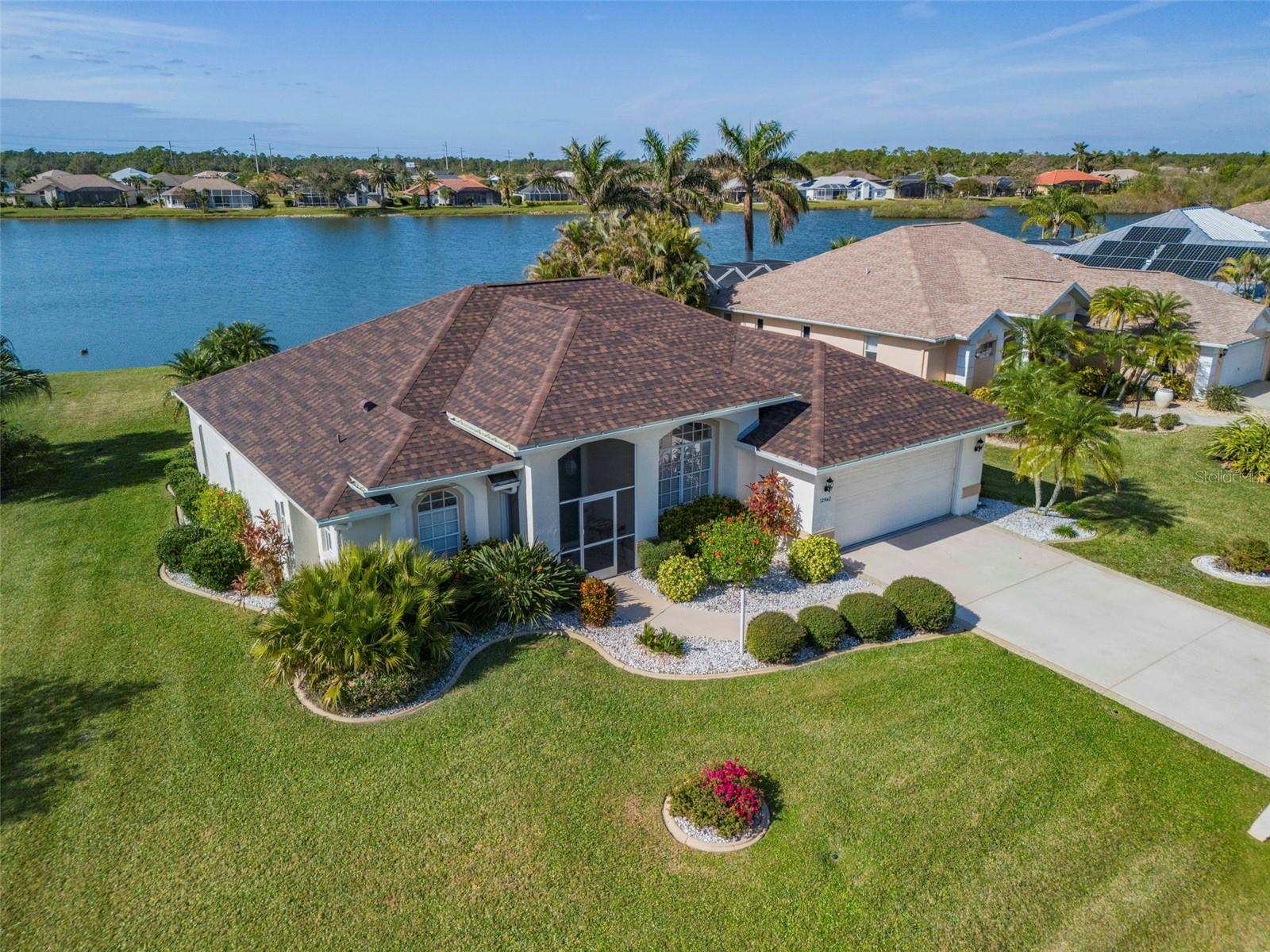 Beautifully designed by MasterBuilders, this lakefront residence captures stunning sunset views across the water and offers the relaxed lifestyle Southwest Florida buyers seek. Situated on an expansive half-acre homesite, the property provides plenty of space to add a private pool while still enjoying generous yard space and peaceful lakefront surroundings.
Designed to embrace indoor-outdoor living, the home features expansive pocketing sliding glass doors in the living room, family room, and primary suite, along with an aquarium window in the family room that frames the lake view and fills the home with natural light. Soaring cathedral ceilings, architectural niches, and Corian kitchen countertops add character and functionality throughout the living spaces. The spacious family room is ideal for entertaining and offers flexibility to convert to a third bedroom if desired.
Enjoy Florida evenings from the oversized screened lanai overlooking the tranquil lake — the perfect setting for morning coffee or watching colorful sunsets reflect across the water.
Important updates provide peace of mind, including a new roof (2022) and a  storm-rated front door was added in 2023.  Accordion hurricane shutters protect the rear of the home, with additional shutters stored in the garage for full coverage.
Located in the desirable deed-restricted Lake Suzy community, residents enjoy a peaceful setting with larger homesites, scenic lakes, and proximity to the Aileron Golf Club, while remaining just minutes from I-75 for convenient access to Punta Gorda, Port Charlotte, shopping, dining, and medical facilities. Gulf beaches, Charlotte Harbor boating, and Southwest Florida’s outdoor lifestyle are all within easy reach.
This home offers an exceptional opportunity to enjoy the comfort, space, and scenic beauty that make Lake Suzy one of the area’s hidden gems.