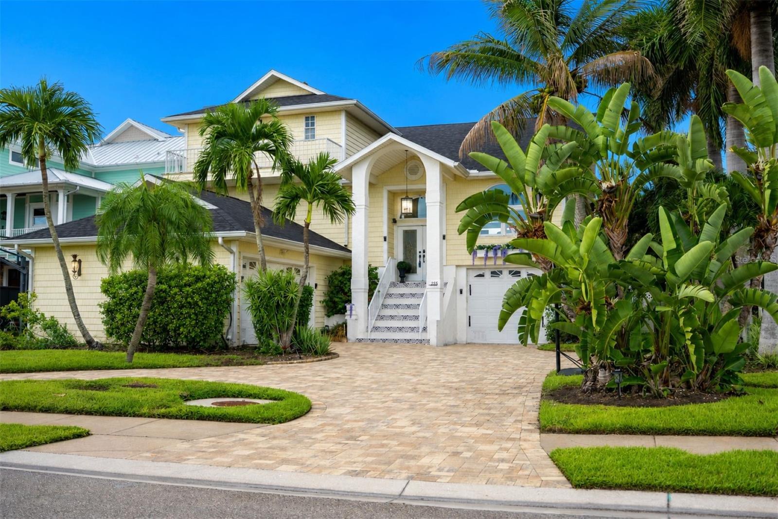 PRIVATE BEACH OUT BACK | WALK TO ST. PETE BEACH 
This Key West-inspired waterfront retreat offers the best of Florida living with a private sandy beach on Boca Ciega Bay, private dock, heated pool and spa, and just a short walk to the white sands of St. Pete Beach. Boasting over 4,000 square feet of living space (5,750+ total gross area), this elevated five-bedroom, four-bath residence features panoramic water views, six balconies and patios, two laundry rooms, multiple gathering areas, and a flexible floor plan ideal for entertaining or multi-generational living.
The main living level features soaring 14-foot ceilings, a dramatic triple-stacked fireplace, floor-to-ceiling glass, and expansive living spaces including both a formal living room and a separate family room, providing plenty of space for entertaining while enjoying panoramic bay views. 
The chef's kitchen offers granite countertops, stainless steel appliances, a center island, dual breakfast bars, and waterfront dining. 
The primary suite enjoys a private waterfront balcony, spa-inspired bath, and walk-in shower. 
The beautifully landscaped backyard is designed for Florida living, featuring lush tropical gardens, a grassy play area ideal for kids and pets, and your own private sandy beach just steps from the home. Outdoor entertaining is effortless with multiple covered balconies, an outdoor breakfast bar, heated pool and spa, and spectacular sunsets over Boca Ciega Bay. A split three-car garage, expansive paver circular driveway, and smart home features complete this exceptional property.
Recent improvements include a new roof (2025), two beautifully renovated bathrooms with modern vanities, fixtures, and tiled showers (2026), a redesigned front staircase with contemporary tile (2026), interior paint, expanded paver circular driveway, and newly epoxied garage floors. New garage doors and maintenance-free vinyl lanai ceilings are scheduled for completion. Offered fully furnished with designer décor, this turnkey waterfront home is just minutes from the Don CeSar, waterfront dining, and everything St. Pete Beach has to offer.