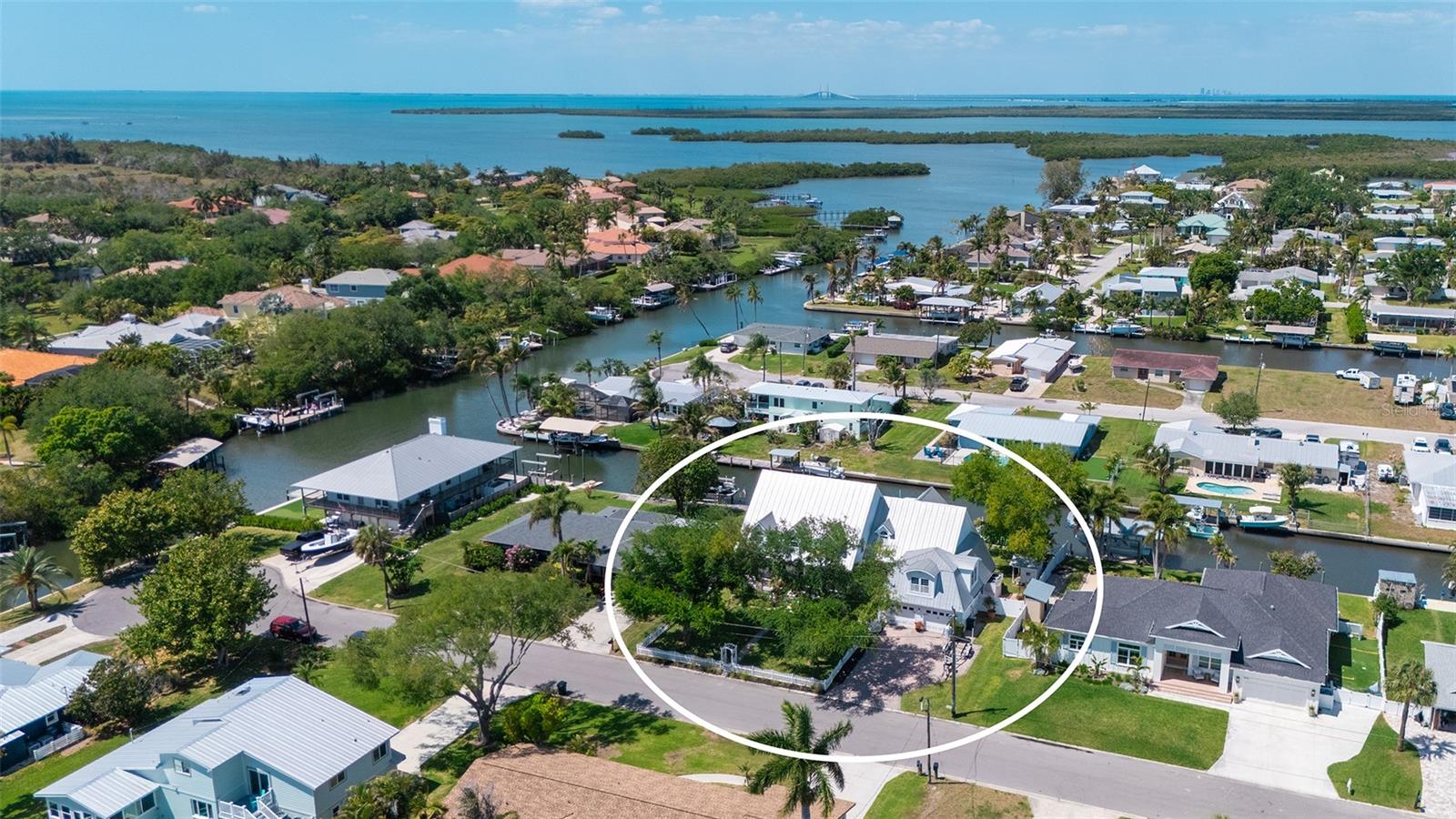 Exceptional waterfront living on coveted Snead Island, where refined coastal design meets effortless boating access just minutes to Terra Ceia Bay and Tampa Bay. Set along a quiet canal with direct access to open water, this beautifully updated 4-bedroom, 3.5-bath residence offers a thoughtfully designed layout with a dedicated office, a media room positioned on its own level for added privacy, and versatile living spaces tailored for both relaxed daily living and sophisticated entertaining. The completely renovated kitchen serves as the centerpiece of the home, featuring custom solid wood cabinetry, Cambria granite countertops, and an AGA range seamlessly integrated into an expansive island. A Bosch dishwasher, premium refrigeration, and thoughtful custom finishes complete this true chef’s kitchen, while 2 1/4-inch oak flooring throughout the first floor adds warmth and timeless character. Framed by soaring ceilings and abundant natural light, the open-concept design flows seamlessly into the main living areas, where architectural detail and curated finishes create a warm yet elevated coastal aesthetic. The first-floor primary suite provides a private retreat, highlighted by a fully renovated, spa-inspired bath and French doors that open to the spacious covered back porch, creating a seamless indoor-outdoor connection. Just off the main living area, a dedicated office with French glass doors overlooks the backyard and canal, offering a quiet and inspiring workspace. Upstairs, three additional bedrooms provide ideal separation for family or guests, including one with a private ensuite bath. Outdoor living is equally inviting, with a heated saltwater pool featuring a new PebbleTec finish and updated equipment, surrounded by generous patio space and tranquil canal views. With direct canal access and quick reach to open water, this home offers a true boating lifestyle paired with thoughtfully updated interiors and a layout designed for both everyday living and entertaining. Ideally located near Emerson Point Preserve, a 365-acre coastal sanctuary of mangroves, wetlands, and natural shoreline, and just moments from the Bradenton Yacht Club, this property is set within Snead Island’s welcoming, close-knit island community known for its boating, fishing, and connection to the surrounding waters.