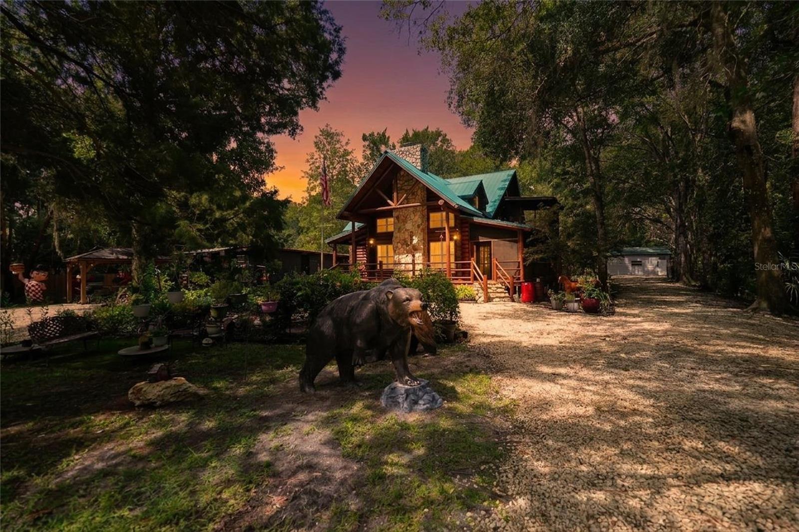 Where Western lodge character meets the laid-back Florida Nature Coast, this extraordinary waterfront retreat offers a lifestyle unlike anything else on the market. Set on 1.16 acres just minutes from the Chassahowitzka boat ramp, this fully furnished Western Red Cedar log cabin was custom designed and built by an architect to maximize natural light, embrace its peaceful surroundings, and showcase the timeless beauty of authentic log-home living. A true wraparound porch, partially screened for year-round enjoyment, creates the perfect setting for morning coffee, quiet afternoons, and sunset evenings. Inside, soaring ceilings, exposed wood beams, beautiful hardwood flooring, and a dramatic floor-to-ceiling stone wood-burning fireplace bring warmth and character to the spacious family room. Milgard double-pane insulated windows enhance energy efficiency while allowing sunlight to fill the home. The newly remodeled kitchen serves as an impressive gathering space with double ovens, a gas cooktop, granite countertops, soft-close cabinetry, custom pullout storage, under-cabinet lighting, and a generous center island. Coordinating cabinetry continues into the utility room, which provides direct access to the wraparound porch. The primary retreat is a destination of its own, featuring a spacious 19-by-10 bonus room ideal for a private office, reading lounge, fitness area, or sitting room, along with its own screened porch for peaceful relaxation. The primary bathroom includes a jetted soaking tub, separate walk-in steam sauna shower, and an oversized 9-by-13.5 walk-in closet with built-in shelving. Designed with accessibility and long-term maintenance in mind, the home was constructed on a cement slab with approximately 40 inches of clearance for convenient access to the plumbing, electrical systems, and ductwork. Outdoor living is equally impressive with a firepit gathering area and a 22-by-30 screened outdoor kitchen equipped with a stove, refrigerator, and large television. A covered boat dock makes it easy to fish, kayak, explore the waterways, or simply unwind beside the water. The RV port can accommodate two recreational vehicles with full hookups, while two detached 22-by-25 fully insulated storage buildings offer electricity, commercial-grade lighting, and commercial fans. One building includes a new mini-split air-conditioning system, and the other has a window unit, making these flexible spaces ideal for workshops, studios, hobbies, vehicle storage, or climate-controlled equipment. The water heater was replaced in 2016, the interior furnishings are included, and the exterior décor is negotiable. Whether used as a full-time residence, seasonal retreat, family gathering place, or potential vacation rental subject to local regulations, this remarkable property delivers rustic elegance, modern comforts, generous storage, and authentic Florida waterfront living. This is not simply a home—it is a private Nature Coast experience.