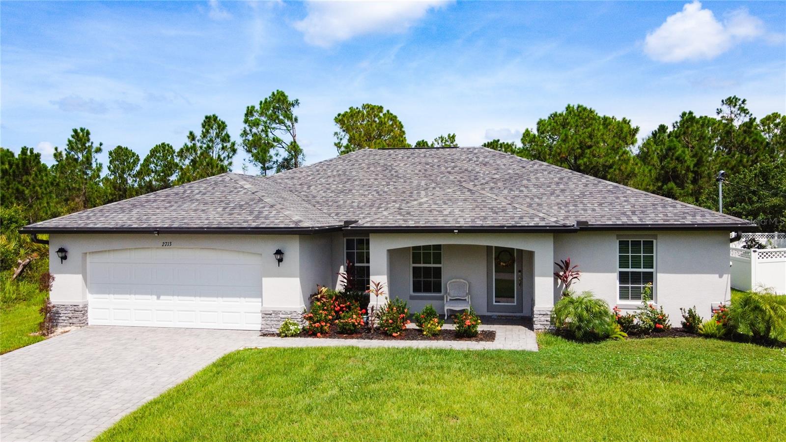 Welcome to your slice of paradise in North Port, Florida. This well-maintained home boasts an open floor plan with a neutral color palette waiting for your personal touch to claim it as your own.  Vaulted ceilings and the open floor plan make this space ideal for entertaining. This two year old home features 4 bedrooms, 2 full bathrooms, a formal dining room, a living room, open kitchen concept, designated laundry room, covered and enclosed lanai, 2 car attached garage as well as closets galore for all your storage needs. Notable features include a 10 year transferable structural warranty (approximately 8 years remaining), PGT IMPACT Low E Insulated windows, high efficiency AC system, stainless steel kitchen appliances, tile throughout, 36” upper kitchen cabinets with soft close doors, granite countertops in kitchen and bathrooms, colonial style raised panel doors, stone accents on the front elevation of the home, irrigation system, epoxy garage floor and a beautiful paver driveway to accentuate outside features. The primary bedroom features an ensuite with walk-in shower and double sink vanities along with dual walk-in closets. The split floor plan includes three additional bedrooms on the opposite side of the home along with a full bath. Ample space for guests and family members or to create a home office. Sliding glass doors transport you from the family room to an outdoor covered and enclosed lanai with a ceiling fan to keep everyone cool while enjoying the scenery of a spacious and lush backyard. Conveniently located near local amenities with easy access to commuter routes as well. This home checks all the boxes so schedule a showing today!