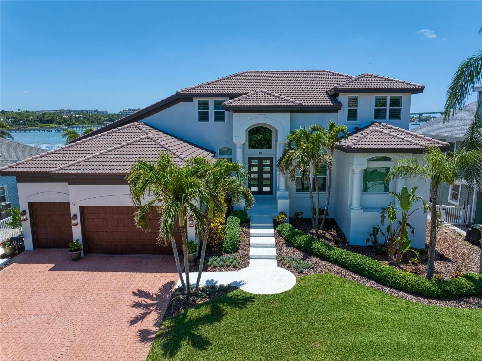 ELEVATED WATERFRONT ESTATE IN PRESTIGIOUS BELLEAIR.

A rare opportunity to own an elevated, pristine open-waterfront estate in the heart of Belleair. Tucked away on a quiet cul-de-sac along sought-after Sunset Bay Street, this exceptional residence offers sweeping panoramic views of Belleair Harbor and the Intracoastal Waterway, with ideal southern exposure for abundant natural light and warm winter sun.
This custom-built waterfront home features 4 bedrooms, 3 full baths, and 2 half baths, encompassing 3,596 square feet of refined living space—truly a boater’s paradise. From the moment you enter through the new designer solid, hurricane-rated double doors, you are immediately drawn to expansive water views, superior craftsmanship, and sophisticated architectural details.
The open great room, gourmet kitchen, and breakfast nook are designed for both everyday living and entertaining, highlighted by soaring ceilings and an exceptionally open floor plan. Floor-to-ceiling PGT impact-rated windows and impact-rated exterior doors create a seamless indoor-outdoor experience while enhancing safety, storm protection, and energy efficiency. The gourmet kitchen features stainless steel appliances, granite countertops, and a wet bar—perfect for hosting family and guests.
The elegant primary suite, conveniently located on the main level, offers tranquil water views and space for a sitting area to enjoy stunning sunrises and sunsets. The newly remodeled primary bath showcases a freestanding soaking tub, walk-in shower, custom cabinetry, double vanities, high-end granite countertops, and modern ceramic tile. A dedicated main-floor office provides an ideal work-from-home retreat.
Recent upgrades include a new ceramic tile roof (2024), full-house Generac generator (2021) on natural gas, new AC systems (2021–2025), tankless water heater (2021), high-impact doors and windows (2021–2023), and a new dock with 13,000-lb boat lift (2021).
Outdoor living is elevated to the next level with an expansive entertaining area and elevated pool, allowing effortless interaction on a single level while enjoying uninterrupted open-water views. The private dock offers deep-water access in a protected harbor—ideal for boating enthusiasts.
Additional highlights include an oversized three-car garage with extra ceiling storage, lush tropical landscaping with mature palm trees, and a high-elevation build that has sustained no hurricane damage in recent storms, underscoring the quality and resilience of the construction.
Enjoy the ultimate Florida lifestyle with a short walk or drive across the Belleair Causeway to the secluded white sands of Belleair Beach, renowned for its uncrowded exclusivity. Steps away are the shops and restaurants of Belleair Bluffs, with Clearwater and St. Petersburg just minutes away for world-class dining, entertainment, and culture. Golfers will appreciate proximity to three Donald Ross–designed golf courses, all within five minutes.
This meticulously maintained waterfront estate offers a rare blend of elegance, privacy, and premier coastal living.