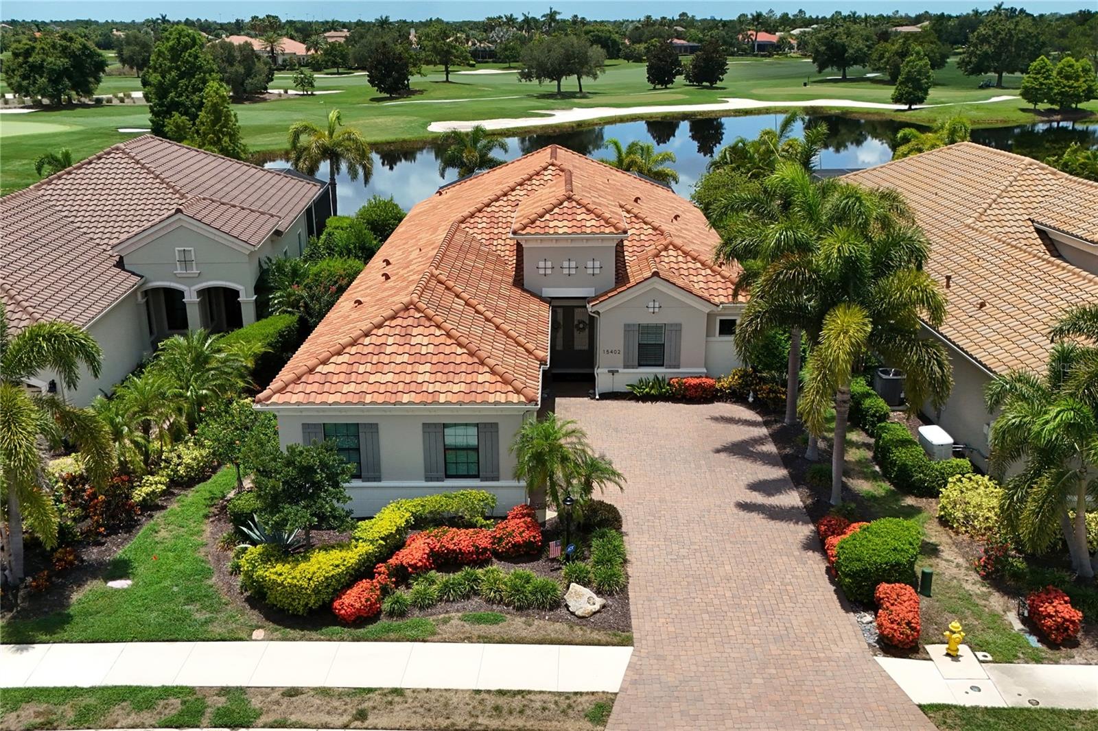 Step into refined luxury at 15402 Castle Park Terrace, an impeccably upgraded Bella Vista model by Neal Signature Homes. Positioned on a premier lot in the prestigious enclave of Country Club East, this 3-bedroom, 3.5-bath, 3-car garage estate boasts expansive, panoramic water and golf course views from the moment you arrive.

A grand double-door entry reveals a sweeping hallway that frames immediate, unobstructed sightlines of the lush fairway. The interior exudes a spa-like elegance, featuring fresh neutral paint, gorgeous plantation shutters, and premium tile flooring throughout—completely free of carpet. Warm wood-tone tile accents anchor the main living spaces and bedrooms, complemented by custom lighting and fans. Designed for effortless entertaining, the grand living area flows seamlessly into a formal dining space, highlighted by custom window shades. The centerpiece for hosting is a phenomenal custom bar, complete with quartz countertops, stone accents, built-in shelving, ambient lighting, and a wine refrigerator.

The light, bright, and masterfully appointed kitchen features miles of quartz counter space, a massive central island, and quiet-close cabinetry with pull-outs and custom hardware. Culinary enthusiasts will appreciate the GE Profile gas cooktop, oven, and microwave, complemented by a brand-new Bosch dishwasher.

The spacious primary retreat offers a private sanctuary with serene water and golf views. It features dual walk-in closets with custom built-ins—including a specialized lockable jewelry door—and a spa-inspired bath with quartz dual vanities, a large walk-in shower, and a private water closet. A dedicated home office impresses with extensive built-ins. Guest accommodations include a spacious bedroom with a private en-suite bath situated at the front of the home, plus a second large bedroom with a walk-in closet and a beautifully updated guest bath featuring an upgraded glass enclosure over a porcelain tub. The meticulously designed laundry room includes quartz counters, built-in cabinetry, a sink, and a drying rack.

Step outside to a spectacular outdoor living area. The heated pool and spa are powered by an upgraded Pentair system, surrounded by a lanai equipped with a motorized SPF sunshade and a natural gas hookup ready for an outdoor kitchen. A dedicated pool half-bath, easily accessible from the lanai, features a new vanity, quartz counters, and custom paint.

This home is fortified with incredible infrastructure upgrades: a Generac whole-home generator, a brand-new AC system, a tankless water heater, and a whole-house water softener with a drinking purifier. The exterior has been recently sealed and painted, the home is protected by an ADT security system, and the 3-car garage features insulated doors. Located mere minutes from Waterside Place, Downtown Lakewood Ranch, and Sarasota’s world-class beaches and cultural mecca.