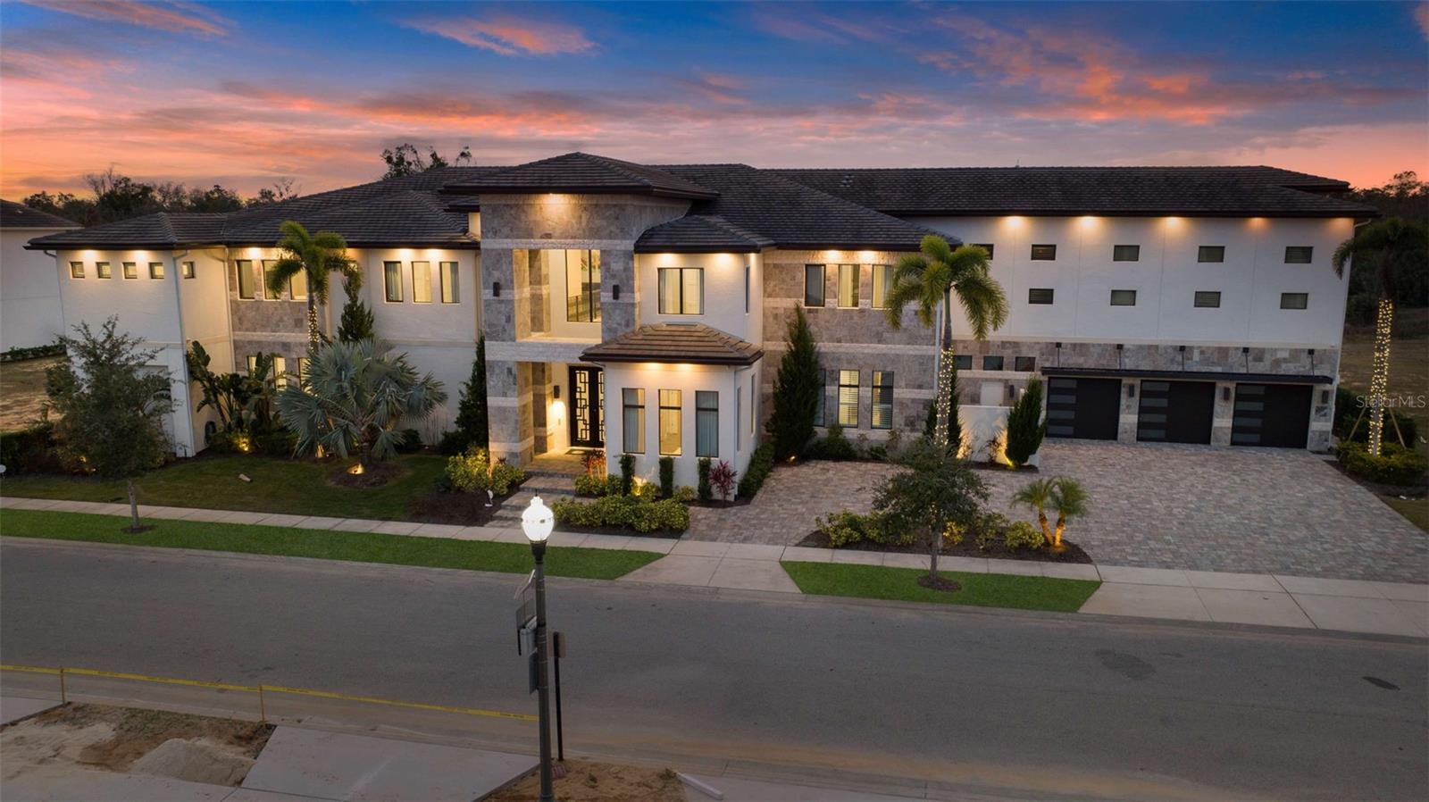 Welcome to 1148 Grand Traverse Pkwy, a stunning 21,397 sq. ft. estate that redefines the meaning of luxury living. This extraordinary 16-bedroom, 18-bathroom home comfortably accommodates up to 36 guests, making it the ultimate destination for family reunions, group retreats, milestone celebrations, or even your dream home for gatherings with family and friends. With its unparalleled amenities and contemporary design, this property is a premier vacation rental with a proven track record of success.
Upon entering this magnificent property, you are greeted by grand interiors with high-end finishes, expansive living spaces, and the ultimate resort living experience Florida has to offer. The chef’s kitchen is a culinary masterpiece, featuring top-of-the-line appliances, stunning stone countertops, a large island for preparing gourmet meals, and an impressive two commercial-sized refrigerators and freezers. The walk-in pantry and seating for 12 provide everything you need for entertaining in style. The adjacent dining area seats 20, creating the perfect setting for shared meals and unforgettable moments. Each of the 16 bedrooms serves as a private retreat, complete with luxurious finishes and spa-inspired en-suite bathrooms. The themed bedroom, inspired by Star Wars, is a showstopper, with a total of 12 bunks and a loft gaming area sure to captivate young adventurers.
1148 Grand Traverse Pkwy is an entertainer’s dream, offering an unmatched array of amenities for both relaxation and fun. The home features a dedicated spa room with a sauna, a state-of-the-art in-home gym for fitness enthusiasts, and a professional-grade golf simulator for those looking to perfect their swing. For sports lovers, there is a ½ court basketball court, while the arcade/game room will provide hours of entertainment with its 2-lane bowling alley, complete with bowling shoes in all sizes for a truly fun-filled experience. Movie lovers will delight in the private theater room, which seats 12 and offers the ultimate cinematic experience.
The outdoor living area is truly a highlight of this exceptional estate. The expansive back patio is equipped with a summer kitchen, perfect for preparing meals and dining al fresco. Numerous seating areas provide space for relaxation, while the hot tub, pool, water slide, and winding lazy river offer endless enjoyment. Whether you are lounging by the pool or enjoying a meal under the stars, the outdoor space at 1148 Grand Traverse Pkwy offers the perfect balance of luxury, leisure, and entertainment.
Reunion Resort is a luxurious vacation destination located near all that Central Florida is famous for and just a few miles from Walt Disney World. Along with 3 signature championship level golf courses designed by golf legends Jack Nicklaus, Tom Watson & Arnold Palmer, you'll enjoy a variety of restaurants from fine dining to more casual options along with poolside bars and coffee shops to start your day while never having to leave the resort. Additionally, there are multiple pools, onsite water park, kid's play areas, tennis, picklelball, fitness center & more.