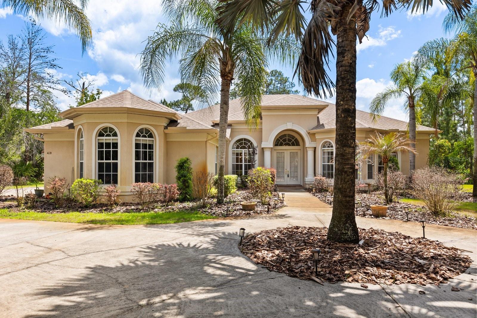 NEW PRICE . . . Welcome to Seminole Woods and to the architecturally intriguing design of this Arthur Rutenberg built home on five wooded acres with over 200 feet of frontage on a private picturesque pond. This spacious single-story home offers four well placed bedrooms, a front-of-the-home office, and a large DR, LR, Kitchen and Family room. As you approach this home for the first time you're struck by the two Tuscan influenced pillars, the high arches over the windows and front entry, and the two wide bay windows on either side of the pillars. The custom designed features continue as you discover the interior: please notice among the many designer upgrades the high recessed tray ceilings, again the Tuscan pillars, the rich crown molding throughout, the wall niches and built-in shelves. From the living room, breakfast nook, kitchen and family room you can enjoy the panoramic view of the pool, and beyond it, down the hill, the private nature-framed pond. The screen enclosed infinity edged pool has a fountain and a heated in-ground spa and is surrounded by genuine fieldstone decking. For your peace of mind, the roof was new in November, 2021; the two air conditioners new in 2020 & 2024; the Generac whole-house generator in May, 2025; the pool heater and pool pump in 2020 & 2022 respectively; and the pool and decking were serviced and leak checked early this year. Seminole Woods is an equestrian community and a nature lover' s dream. Amenities include miles of trails for horses and hikers, and a gated park on full-use skiable Buck Lake with a dock and boat launch, a picnic pavilion, sports courts and playground.