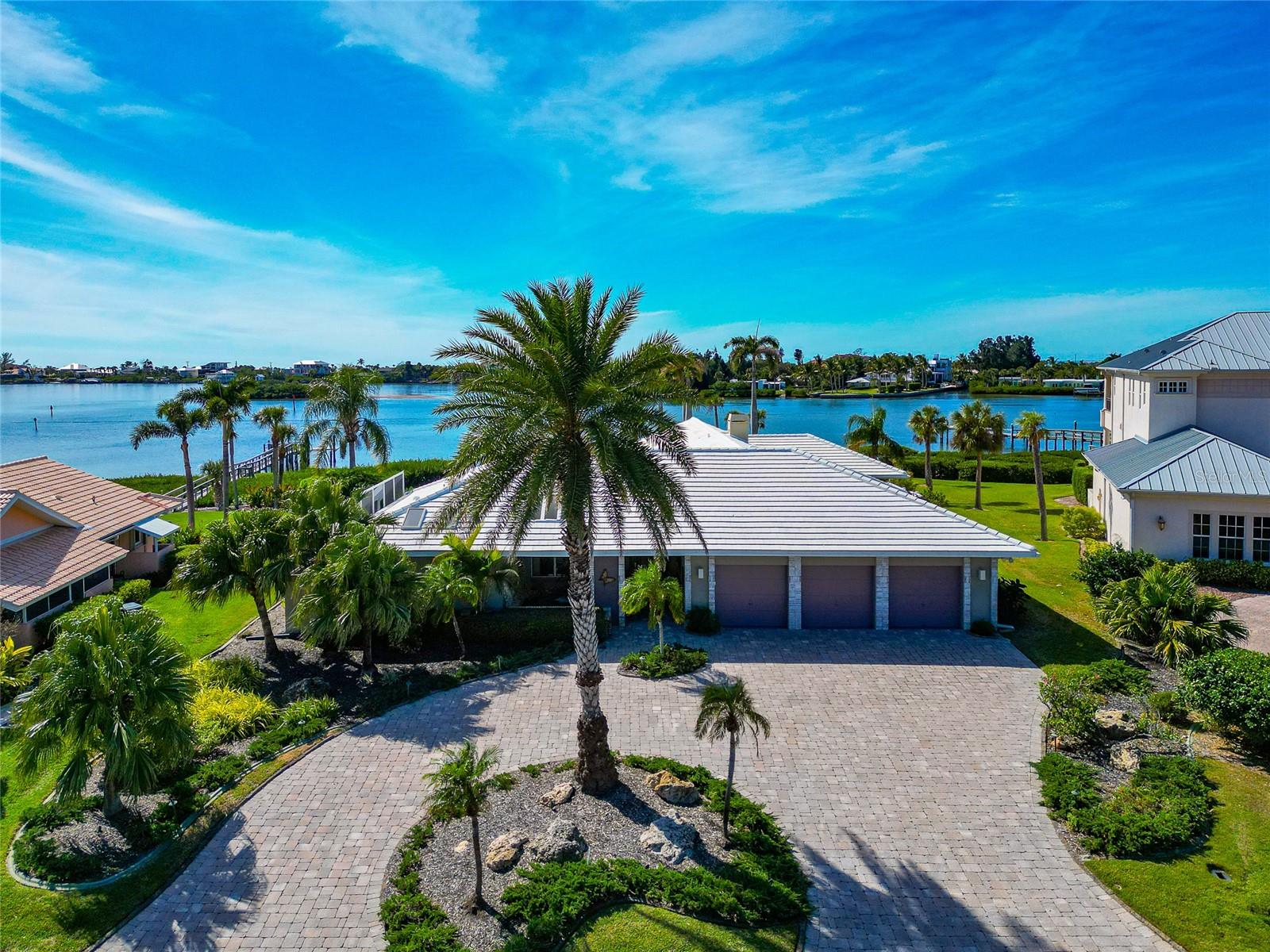 Ahhh…you have finally found “the one”!  This home  is a one of a kind property with one of the best water front lots in Southbay! Features of this spectacular home include not only a lagoon style pool with waterfall,  but a lagoon with a winding deck bridge walkway taking you past another waterfall,  to the intracoastal water way!  Imagine your morning coffee or evening sunsets “sitting by the dock of the bay”.   Inside, this home is filled with character.  Etched glass panels tell a story in the master bedroom. The office has built-in cabinetry and etched glass panels.  The master bathroom has sliding glass doors to outdoor shower and zen area…just to name a few.  One of the many exciting features of this home is the 4th car garage, the auto atrium!  Car enthusiasts, you now have a place to show off your pride and joy!  This home was built with quality and the kitchen shows that off.  Glossy high end cabinetry and built-in luxury appliances have a timeless beauty.  The roof was replaced in 2022 and 3 new air conditioners were installed in October, 2025. The community of Southbay offers a deep marina to handle just about any size boat.  Southbay is an active community with many social, sports and boating activities.  The remodeled clubhouse is the heartbeat of the community including a fitness room, game room, two kitchens, card room, ball room, elevator, even a baby grand piano!  Southbay is located in a convenient and central location just a short drive to several area beaches, shopping, restaurants,  downtown Venice or Sarasota.  The famous Casey Key Fish House and Tiki Bar are close by - an easy golf cart ride away.  This home is ready for you to start living the vibrant Southbay lifestyle!
