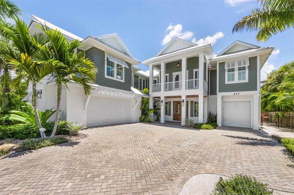 Custom waterfront residence just a short walk to the Gulf of Mexico beaches. This home features 4 bedrooms all with spacious en suite baths, half bath off the living area, custom cabinetry, quartz counters, gas fireplace, wood beam detail in the great room, wood flooring throughout, elevator, impact windows and doors. The kitchen, open to the great room offers a stand alone island, breakfast nook, Thermador appliances, double refrigerators and a 6 burner gas stove. Across from the kitchen is a wet bar with wine refrigerator. Enjoy palm tree lined views from multiple vantage points in the great room and kitchen that offers lots of natural light. The master suite has a private balcony with water views, walk in closet and a rich master bath with free standing tub, walk in glass shower and double vanity. The main guest suite is a wing of its own with a private covered porch, coffee bar with beverage refrigerator, walk in closet and a walk in glass shower. The travertine lined outdoors is the wow factor of this home with spacious outdoor living and dining areas that surround the impressive free form heated pool and spa with cocktail table and sun shelf. Deep water dockage, outdoor shower, 2 car side entry garage along with a separate 1 car garage for your golf cart and all the toys.