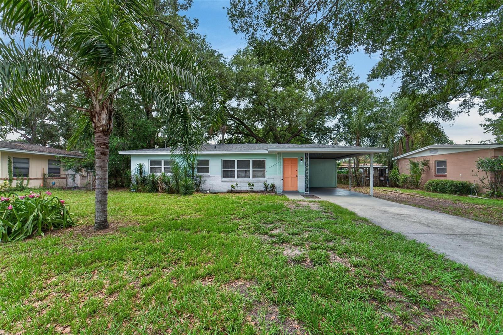 Welcome to Woodlawn Terrace. This 3-bedroom, 1.5-bathroom home offers a practical layout, solid construction, and a location that keeps you connected to everything Tampa has to offer. Tucked into the northern portion of Tampa’s urban core, the property is ideal for buyers looking for space, functionality, and convenience without sacrificing yard size or character.

Built with concrete block construction, the home provides an alternative to traditional wood-frame housing. The generously sized lot features approximately 67 feet of frontage and 103 feet of depth, with a backyard shaded by mature grandfather oaks that create the perfect setting to design your own outdoor retreat.

The property also features a dog-trot style storage and laundry room located at the end of the carport, adding extra utility and charm. Inside, you’ll immediately notice the oversized ceramic tile flooring with a bold obsidian-inspired appearance, paired with freshly painted white walls that brighten the space throughout. Natural light fills the living area, while the open-concept layout allows for easy interaction between the kitchen and living room, making the home feel comfortable for both everyday living and entertaining.

The kitchen has been tastefully updated with shaker-style cabinetry, granite countertops, and like-new stainless steel appliances that give the space a clean, modern feel. The bedrooms currently feature carpet, giving the next owner the opportunity to personalize the flooring to their own style over time.

Major components have already been addressed, including a permitted roof installed in 2023, water heater replaced in 2019, and an HVAC system that has been recently serviced and is operating well.

Schedule your showing today and come experience this teal Woodlawn Terrace home for yourself.
