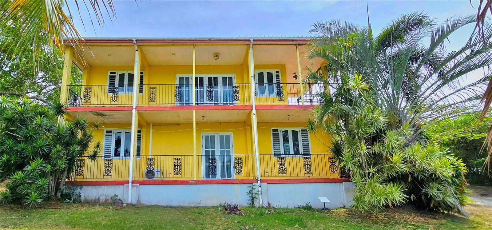 Brimming with character and renovation potential, this two-story Caribbean-style residence sits on approximately one and a half acre of lush tropical grounds.  It's approximately 850 meters from world-renowned Flamenco Beach, roughly a 10-minute walk or a 2-minute drive. Built with the Force 10 Engineered Building System, the home features galvanized steel frame construction with insulated cement-fiber wall panels and a Colorbond steel roof, engineered to withstand wind speeds up to 160 mph and built on reinforced concrete foundations.  A robust hurricane-resistant building system originally tested by Queensland University of Technology. The structure has stood through Hurricane Irma (2017, Category 5) and Hurricane María (2017, Category 4), a testament to its engineered design. The home's balconies on both levels are ideal for enjoying the Caribbean breeze while taking in sweeping vistas of the Flamenco lagoon and surrounding hillsides. Inside, terracotta tile floors run throughout and French doors open to the balconies and the views. A spacious kitchen anchors the main living area, featuring a center island with gas cooktop and bar seating area, granite countertops, and ample cabinet storage. The home offers 2 bedrooms and 2.5 bathrooms across two levels, with the upper floor accessed via an exterior staircase. The property will require meaningful renovation and repairs throughout, offering a rewarding opportunity for buyers with vision to restore and personalize a Culebra residence to their own taste. Mature tropical landscaping with palms, banana, and fruit trees surrounds the home. The large yard offers generous room to expand the outdoor living experience, ample space for a future pool, lounging patios, or additional structures.