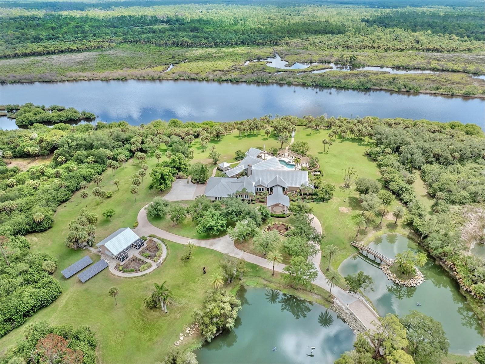 Virtually Staged. One of Sarasota County's Most Unique Waterfront Properties on 15 Acres Along the Myakka River! Set behind the gates of Myakka River Trails, this exceptional riverfront estate offers 15 acres along the Myakka River, 6,539 square feet of living space, and a rare blend of privacy, scale, and refined indoor-outdoor living. A grand approach begins as you enter the property via a beautifully crafted stone bridge spanning tranquil ponds accented by elegant fountains leading to a circular drive, covered entry approach, and a striking front entrance that sets the tone for the property. Inside, high and cathedral ceilings, travertine and wood flooring, plantation shutters, and thoughtful architectural details create an elegant yet welcoming atmosphere. The split-bedroom floor plan offers excellent flow, with generous gathering areas and well-placed private spaces throughout the home. The impressive primary suite features two walk-in closets, a sitting area, direct lanai access, and a spacious ensuite bath with dual sinks, a garden tub, walk-in shower with bench seating, and abundant storage. The chef’s kitchen is designed for both everyday comfort and elevated entertaining, featuring stainless steel appliances, double ovens, a sub-zero refrigerator, two sinks, granite countertops, thermador gas stove, miele coffee maker, breakfast bar seating, wood cabinetry, recessed lighting, extensive storage, and a walk-in pantry. The adjoining family room makes a grand statement with a large stone fireplace, built-in shelving, and space for both casual dining and a breakfast nook. A formal dining room with a beautiful chandelier and separate wet bar adds another polished setting for hosting. The home includes five bedrooms and five baths, highlighted by a large in-law suite with private bath and a separate casita with its own bedroom, bathroom, walk-in closet, and private courtyard access. Two additional bedrooms each include a walk-in closet and ensuite bath, with an office positioned between them. A large laundry room offers ample cabinetry, workspace, and a utility sink for added function. Outdoor living is a defining feature of this estate. A massive screened and covered lanai stretches across the back of the home, opening to an expansive pool area with spa, multiple lounging spaces, a stylish pergola, and a full outdoor kitchen under pavilion with bar seating, sink, countertop workspace, and oven. A wood-burning fireplace adds warmth and ambiance to the resort-style setting. The property also includes an oversized 2,000+ square foot garage with workshop, office space, and fitness room, along with a separate barn ideal for storage or potential stable conversion. Along the river, a dock (to be completed July 2026) offers a peaceful place to take in water views and the natural surroundings. Additional highlights include new landscaping completed in June 2026, hurricane shutters, artistic sculptures throughout the grounds, a garden, and access to community amenities including a pool, screened pavilion, playground, and tennis courts. Located near Wellen Park, CoolToday Park, golf courses, parks, I-75, grocery, shopping, and dining, this luxury estate offers a rare combination of acreage, river frontage, privacy, and convenience in one of Venice’s most distinctive gated communities. Schedule your private showing to experience the scale, setting, and craftsmanship of 630 N River Road.