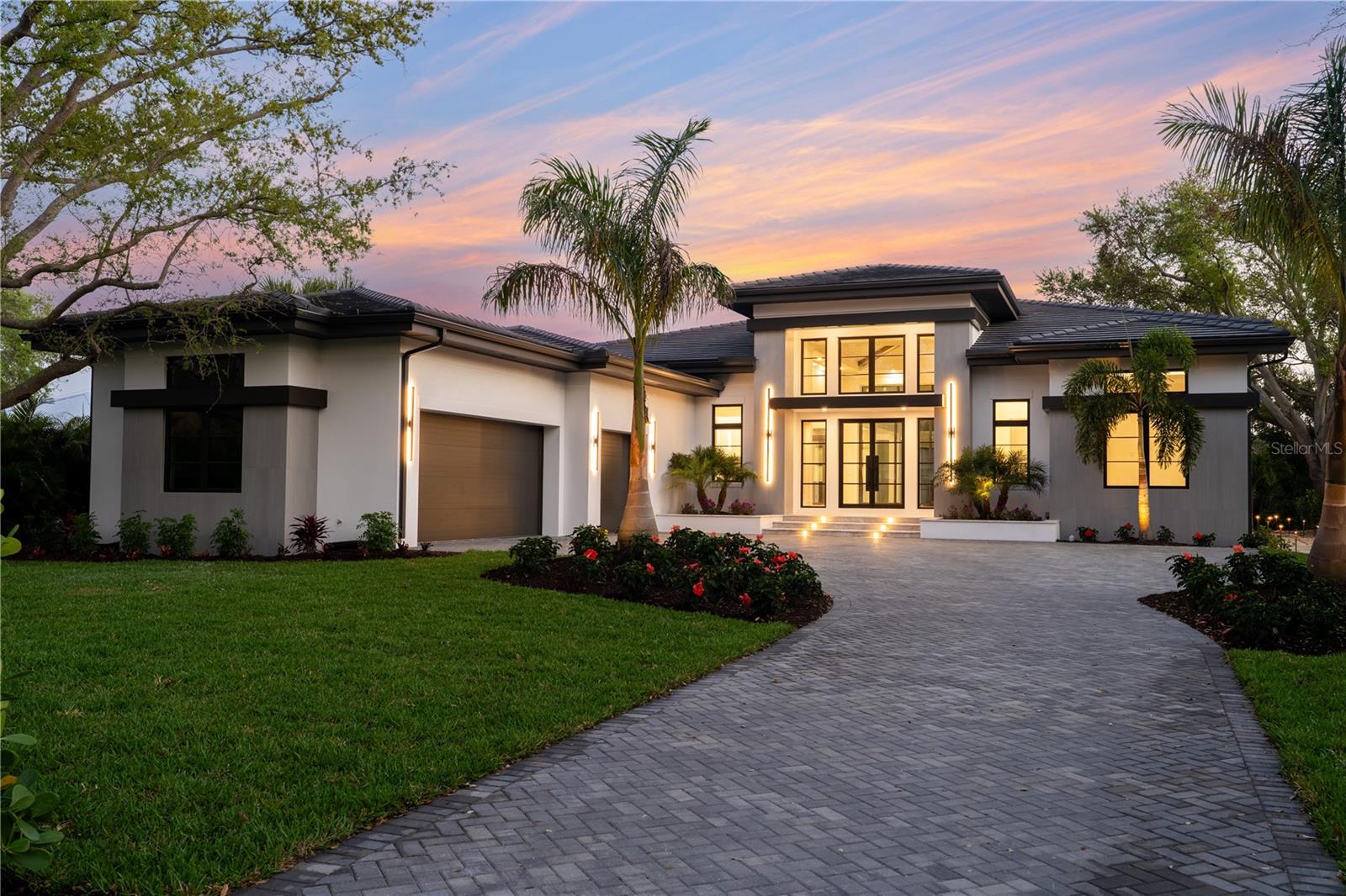 Completed and Move-In Ready. A rare opportunity to own a newly completed custom residence by Nutter Custom Construction, thoughtfully designed and set on an expansive homesite in the sought-after Field Club Estates. Spanning over 4,000 square feet, this single-story home blends refined architectural detail with a layout that offers both openness and privacy. A striking arrival is framed by mature palms and lush landscaping, complemented by a three-car side-load garage with epoxy flooring and a grand iron front door that sets the tone for the home’s elevated design. Impact-rated windows and sliding glass doors, along with solid core doors throughout, further enhance both quality and comfort. Inside, the home unfolds into a grand great room with soaring 15.5-foot ceilings, naturally aged flooring, and expansive 10-foot sliding glass doors that create a seamless connection to the outdoors. The kitchen is designed for both everyday living and entertaining, featuring an oversized island, custom wood cabinetry, luxury appliances, and a gas cooktop, along with a spacious walk-in pantry. The primary suite serves as a private retreat, thoughtfully positioned to capture serene views of the pool and tranquil pond beyond. This space features dual walk-in closets, custom cabinetry, and a spa-inspired bath complete with a soaking tub and a beautifully appointed walk-in shower. Two additional guest suites offer en-suite baths and walk-in closets, while a fourth bedroom is thoughtfully designed to function as a private casita or pool bath with dual access from both the interior and lanai. A media lounge with disappearing corner sliders enhances the home’s indoor-outdoor flow, opening to a resort-style outdoor living space. The covered lanai is designed for year-round enjoyment, highlighted by a 72” ventless gas linear fireplace, a fully equipped outdoor kitchen, and a dedicated dining area. The pool and spa are gas-heated and perfectly positioned to capture tranquil pond views, with a sun shelf and expansive deck creating a true backyard retreat—all enclosed within a clear-view screen for unobstructed views. Designed to balance luxury living with a serene natural setting, the home is equipped with gas service for the cooktop, water heater, outdoor kitchen, and pool/spa heater, offering both efficiency and elevated functionality. Ideally located, it provides convenient access to Sarasota’s renowned beaches, downtown, dining, and shopping.
Please inquire for a complete list of features and specifications. Please note: Some photos have been virtually staged for illustration purposes.
