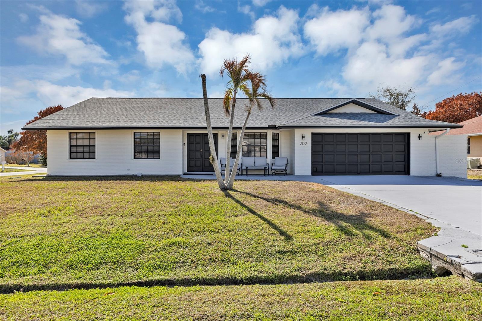 Welcome to 202 SW Holden Terrace a beautifully updated 4-bedroom, 2-bath home positioned on a spacious corner lot in a peaceful Port St. Lucie neighborhood with no HOA. Vaulted ceilings and a functional floor plan create an ideal balance of openness and privacy throughout the home.

The inviting family room is centered around a cozy wood burning fireplace, offering the perfect backdrop for relaxing evenings or gathering with friends and family. Fresh interior paint enhances the bright, airy feel from room to room.

Recent improvements provide valuable peace of mind, including a new roof, water heater, washer, dryer, refrigerator, and dishwasher allowing an extra level of comfort.

The freshly painted 2-car garage with a solid wood garage door adds both curb appeal and practicality. For modern convenience, the home is equipped with two fast EV charging stations, making it ideal for electric vehicle owners.

An additional rear parking area offers excellent space for RVs, boats, or recreational toys with no association restrictions which is a rare find. Two storage sheds provide added versatility, and the expansive corner lot enhances privacy and usability.

Enjoy true Florida living from the enclosed patio/bonus room that leads outside to a beautifully maintained and open backyard. A whole-house generator provides added confidence and preparedness year-round.

Conveniently located near area parks, major freeway access, and the excitement of St. Lucie Mets games, this property combines everyday convenience with a quiet residential setting.

Offering space, thoughtful updates, flexibility, and freedom. This is a home that truly checks all the boxes. Don’t miss your opportunity to make it yours.