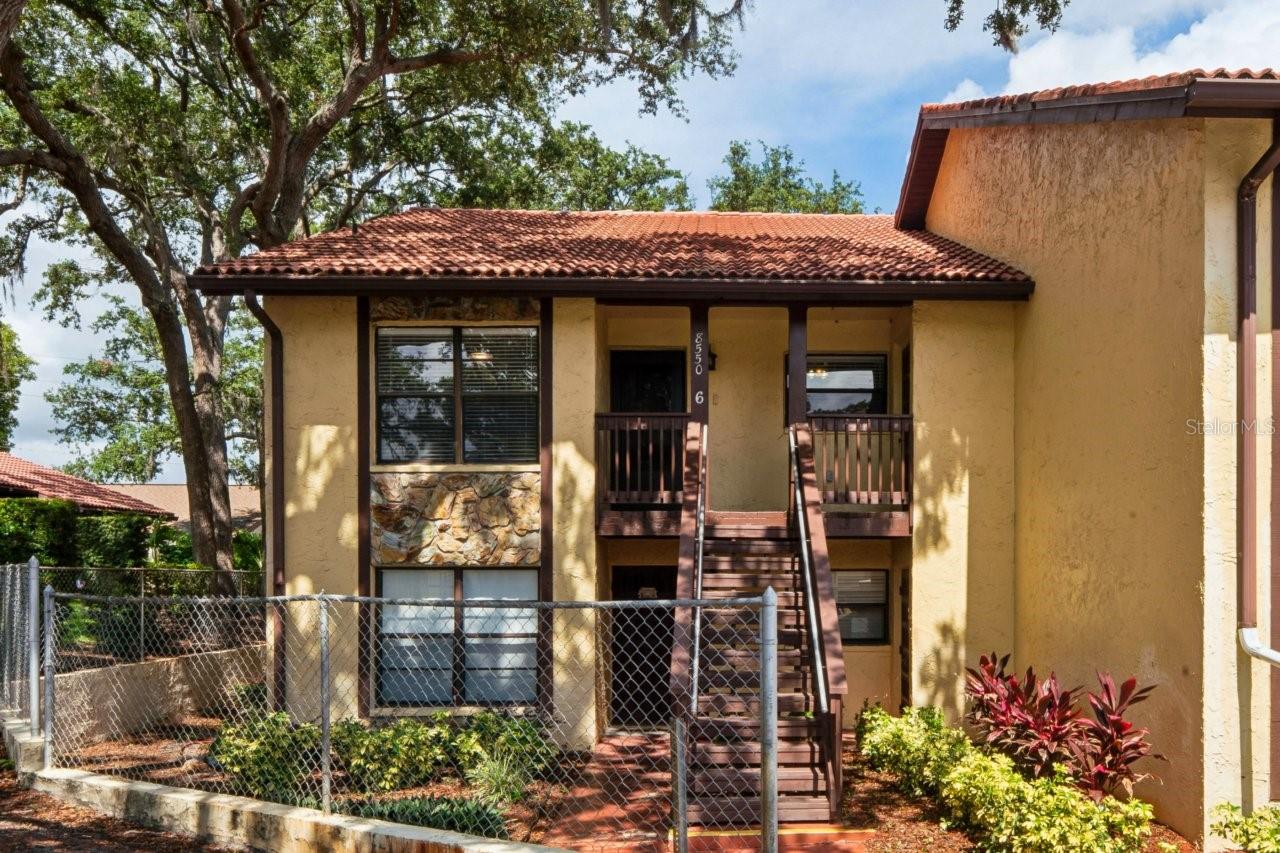 Welcome to this well-maintained second-floor corner unit offering comfortable, maintenance-free living in a quiet, pet-friendly community with no age restrictions. This inviting two-bedroom, two-bath home features walk-in closets in both bedrooms, a spacious combined living and dining area, and an eat-in kitchen with a water filtration system and a brand-new, never-used dishwasher. Interior highlights include ceramic tile and laminate flooring, carpet in the bedrooms, ceiling fans in most rooms, a dry bar with built-in storage in the living room, an additional storage closet, pull-down attic stairs, and a laundry closet conveniently located in the primary bedroom. Enjoy outdoor living with both a front porch and an enclosed lanai. The community offers a clubhouse, fitness center, pool, and an assigned carport.  While the convenient location is near schools, as well as shopping, parks, and beaches, the airport is less than an hour away, and Disney is under two hours away.
