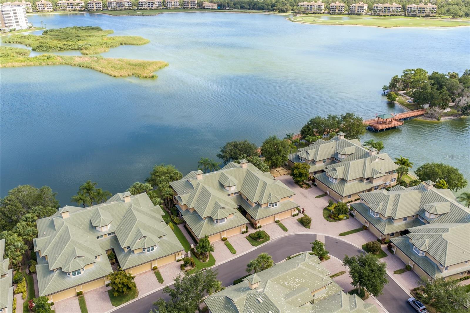 Breathtaking panoramic water views over the 168 acre Lake Uihlein reigns from this sought-after and rarely available Kestrel floor plan in The Moorings at Edgewater with 2,963 square feet of living space. This two story residence offers peace of mind with all IMPACT windows and sliding doors, NEW tile ROOFS replaced between 2022-2024 in the community, and the luxury of a private ELEVATOR, updated kitchen, three ensuite bedrooms, and an attached two car garage. 

This expansive two-story lives more like a single family home with its three generous ensuite bedrooms, three and a half baths and a luxuriantly appointed great room, wet bar, sitting room, dining area and kitchen adorned with crown moldings, neutral tile flooring, and plantation shutters creating a bright and fresh continuity of space. Meanwhile the remodeled kitchen and wet bar further accentuate with solid maple cabinetry, waterfall quartz counters, dovetail soft-close drawers, under cabinet lighting, large customized pantry, newer stainless steel appliances, and an inviting  breakfast nook surrounded by glorious lakefront vistas. 

Rest and relaxation awaits in the owner’s quarters positioned on a private wing offering water views, direct balcony access via impact sliders, tray ceilings with crown moldings, plantation shutters, two customized walk-in closets, and a remodeled bathroom suite with dual sink vanity station, Hansgrohe & Kraus fixtures, an abundance of new cabinetry, an oversized invigorating rainfall shower, jetted soaking tub, plus separate water closet. Two additional guest rooms are generous in size, both with ensuite full baths and walk-in closets. The residence also offers a powder room off the living area and a private office or hobby room on the main level just off the garage, entry foyer and elevator. 

Additional highlights of this waterfront residence includes a welcoming guest entry gate, laundry room with cabinetry and 2024 washer and dryer, 20' foyer ceiling grand entrance, Tobacco Road acacia staircase, a screened balcony accessible via great room, kitchen and primary suite, all impact windows and sliders, 10' ceilings and 8' interior doors, 15+ SEER Trane HVAC with Nexia/Trane Smart programmable thermostat, pavered walkways, an oversized two car garage, and the peace of mind of all new tile roofs in the community replaced between 2022 - 2024. 

Residents of The Moorings at Edgewater enjoy private access to Moorings Point Island on Lake Uihlein with walkways, kayaking, canoeing, a fishing pier, gazebo lush tropical landscaping, while the clubhouse offers its residents an on site manager, social monthly events, a heated pool/spa, fitness center, library, pool table, kitchen, outdoor grill, dining area, tiki bar, and even a private boat club catering to water enthusiasts.  This gated community is next door to Lakewood Ranch Main Street, ideally located within the nation’s #1 top-selling master-planned community known for its vibrant lifestyle, dining, shopping, farmer’s market, and countless community events.