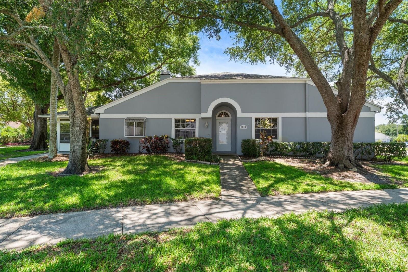 Virtually Staged. Welcome to this beautifully maintained 3-bedroom, 2-bath end-unit villa in the highly sought-after Baytowne West community of Safety Harbor. Offering 1,445 sq. ft. of living space plus an impressive 340 sq. ft. enclosed lanai, this home provides plenty of room to relax, entertain, and enjoy the Florida lifestyle. Inside, you’ll find laminate flooring throughout the main living areas, tile flooring in the kitchen, cathedral ceilings, a cozy fireplace in the living room, and a separate dining area. The updated kitchen features dark espresso brown kitchen cabinets, granite countertops, stainless steel appliances, and a functional layout perfect for everyday living. A hurricane-rated slider off the kitchen opens to the enclosed lanai, creating a seamless connection between indoor and outdoor living. The home also offers inside laundry and two assigned parking spaces directly in front of the villa. Situated on a large lot, this end unit provides added privacy and outdoor space. The low monthly HOA fee includes cable, exterior paint, lawn care, irrigation, pool, and spa access. Ideally located near vibrant Downtown Safety Harbor, Phillippe Park, bike trails, pickleball courts, shopping, dining, and more, this villa combines comfort, convenience, and an unbeatable location.