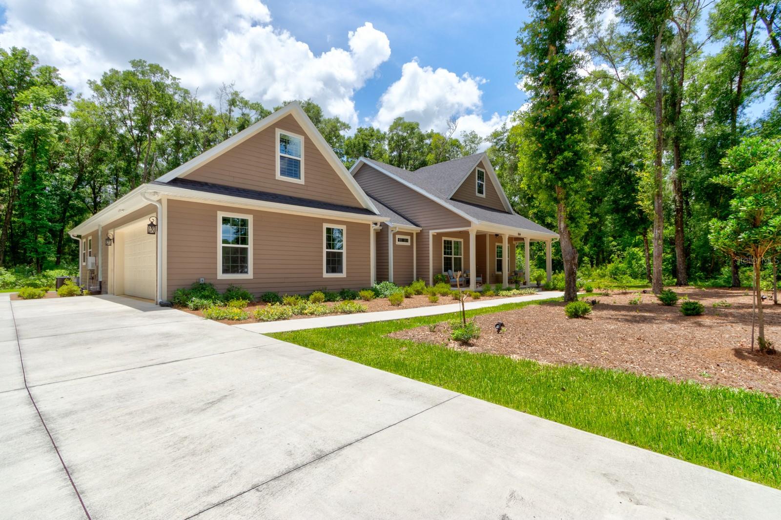 One or more photo(s) has been virtually staged. Welcome to 3504 Dunstable Drive in Glenwood Reserve, a custom 2024-built home that feels less like typical newer construction and more like a private retreat designed with real life in mind. Set on over an acre with a natural wooded conservation/preserve backdrop, this 4-bedroom, 3.5-bath home gives buyers the space, privacy, flexibility, and quality that are increasingly hard to find at this price point. From the rocking-chair front porch to the long driveway, mature trees, and quiet cul-de-sac setting, the arrival immediately feels calm, private, and set apart. Inside, the home opens with warmth and polish rather than the cold, cookie-cutter feel found in many newer homes. Bamboo flooring, 10-foot ceilings, 8-foot doors, plantation shutters, custom trim work, and a thoughtfully designed floor plan create a sense of quality throughout. The main living area is centered around a double-sided gas fireplace, connecting the great room to the rear outdoor living space and giving the home a natural gathering point for relaxing evenings, family time, or entertaining. The kitchen sits at the heart of the home with granite countertops, shaker soft-close cabinetry, gas cooking, stainless steel appliances, double oven, dedicated pantry space, and a coffee station/butler’s pantry area that adds both function and everyday convenience. The layout is one of the home’s strongest advantages. The primary suite is privately positioned with dual vanities, his-and-hers closets, a private commode area, walk-in shower, and a comfortable retreat-like feel. On the main level, two additional bedrooms provide excellent flexibility, including a standout private guest wing where one bedroom connects to a kitchenette/flex space with its own exterior access to the screened porch. That space gives the home rare versatility for extended guests, in-law-style use, a private office, hobby space, or simply a separate retreat within the home. Upstairs, the fourth bedroom/flex suite includes a window, dedicated mini-split A/C, and attached half bath, making it ideal for guests, media, office, fitness, recreation, or a private teen/bonus space. The home also offers the practical upgrades buyers appreciate after they move in, including no-step showers, water purification, tankless water heater, gas appliances, spray foam insulation, block and Hardie board construction, gutters with guards, motion sensor lighting, and ceiling fans throughout. The oversized garage is another major selling point, offering epoxy-style flooring, wash sink, windows, a higher-clearance hurricane-rated garage door, and room for larger vehicles or trucks. Outside, the screened rear porch, outdoor shower, wide rear sidewalk access, and peaceful wooded backdrop make the property feel connected to nature without giving up convenience. Glenwood Reserve is known for spacious one-acre homesites and a quiet low-density setting while remaining convenient to DeLand shopping, dining, schools, parks, downtown, and major routes. If you have been waiting for a newer custom home with privacy, quality construction, flexible living spaces, and a setting that truly feels special, this property deserves to be seen in person. Dining room chandeliers do not convey.
