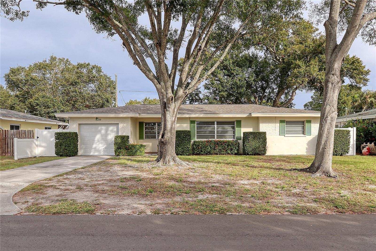 Whether you're drawn to the nostalgia of the past or see the potential for a modern touch, this home offers a unique canvas for your personal style.  Step inside and discover appealing tile flooring and windows that fill the living spaces with natural light.  The functional layout includes  spacious living and dining areas and a vintage kitchen and bath that showcase the classic design of the era for those who enjoy the authenticity of mid-century design. Boasting 2 bedrooms and 1 bath, this home offers a warm and inviting atmosphere and is well-maintained with a new roof 2021, new HVAC 2016, and new water heater 2017.  The large vinyl fenced back yard is a private outdoor space for relaxation or entertaining. The 1 car garage houses the washer and dryer hook-ups and adds practically ensuring both shelter for your vehicle and additional storage.  Situated in a central Clearwater location, the home provides convenience and accessibility to shopping, entertainment, airports and our beautiful award winning beaches.