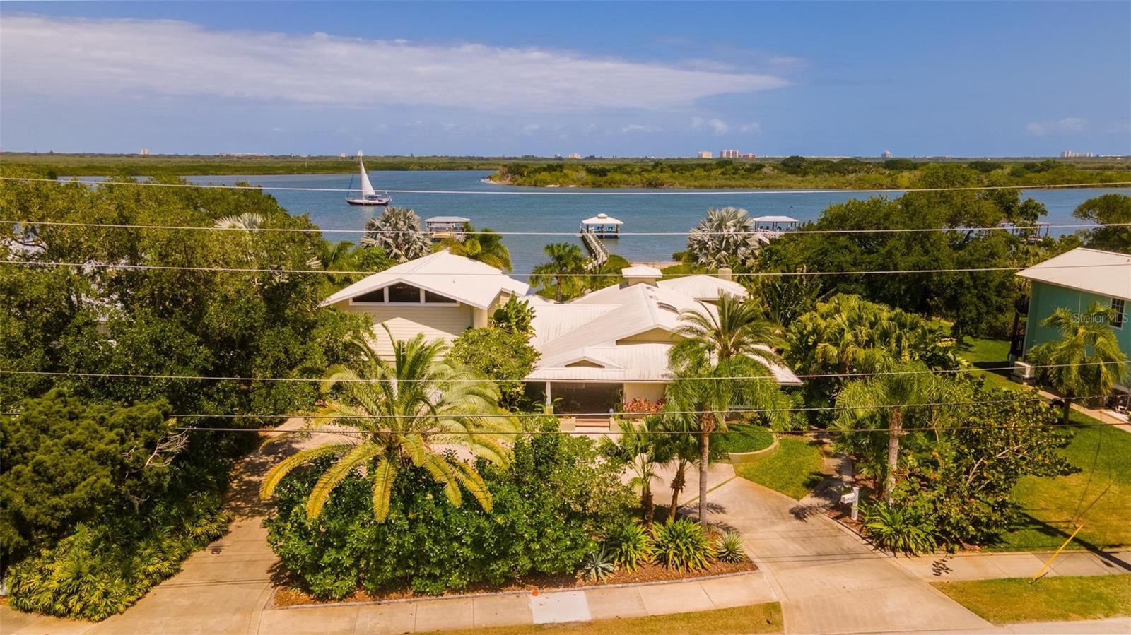Custom Intracoastal 4 bedroom, 4.5 bath residence with fabulous pool, lanai and dock. Situated on almost half an acre, this property offers an amazing amount of privacy with stunning views. Ideal floorplan features master suites both upstairs and down. Another suite has sitting room and separate entrance and makes ideal in-law quarters. The kitchen is built for entertaining with large bar and large island providing lots of room for family and friends to gather. Stainless appliances, beautiful Cherry cabinetry, gleaming granite and tons of cabinet and counter space plus a perfectly situated butler’s pantry and laundry make multi-taking and organizing a breeze. The cozy family room with natural gas fireplace overlooks the lanai. The master suite has cathedral beamed ceilings, private riverfront balcony and marble bathroom with whirlpool tub. The downstairs suite overlooks a peaceful tidal cove. Travertine floors and Ipé decking. Jeldwynn impact windows, sliders, french doors and beautiful custom woodwork throughout. The covered lanai with wood-burning fireplace and summer kitchen overlook the resort-like gas heated salt pool and spa with private pool bath and changing room. Natural gas for tankless water heater, 16000kw generator, stove and summer kitchen. Covered dock with lift.  Furniture negotiable.  Note: A small portion of the home was existing in 1986 and was completely renovated in 2007 along with new additions & a second story.