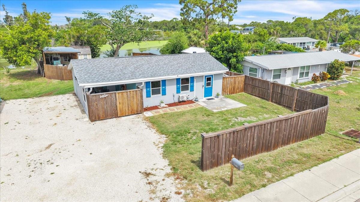Enjoy peaceful waterfront living in this charming 1-bedroom, 1-bathroom lakefront home, perfectly positioned on a spacious lot with beautiful water views and a relaxed setting. This cozy residence offers inviting curb appeal with bright blue shutters, a functional layout, and the versatility to serve as a full-time residence, seasonal retreat, or investment property. Recent updates include a new mini-split air conditioning system installed in June 2026, impact windows for added storm protection and energy efficiency, and a water heater installed in 2019. The property also offers the benefit of transferrable insurance, providing added peace of mind for the next owner. The property features a covered carport with front doors for convenient protected parking, along with a large gravel driveway providing ample space for vehicles, boats, RVs, or trailers. A fully fenced yard offers privacy and plenty of room for pets, outdoor activities, and entertaining. A new mini split A/C installed in June 2026Step inside to a bright and welcoming open-concept living and dining area showcasing terracotta tile flooring throughout, coastal-inspired finishes, and a warm, comfortable atmosphere. Decorative shiplap walls, custom built-in shelving, and a stylish electric fireplace create a charming focal point perfect for relaxing evenings or entertaining guests. A versatile bonus room provides additional living space ideal for a home office, hobby room, guest area, or extra storage to suit your needs. The bright kitchen features white shaker cabinetry, butcher block countertops, a subway tile backsplash, and pantry storage overlooking the living area. The inviting bedroom retreat offers decorative paneling, and generous closet storage with classic louvered doors. The adjoining bathroom has been tastefully updated with timeless white subway tile, a tub/shower combination with frosted glass enclosure, a modern vanity, and built-in shelving for added convenience. Step outside to the expansive backyard designed for both relaxation and functionality. A charming deck provides the perfect spot to enjoy morning coffee or unwind while taking in the peaceful waterfront views. The property also includes a covered boat shed with a concrete pad, offering protected storage for your boat, trailer, or recreational equipment, along with a separate 10x20 storage shed/workshop for tools, hobbies, and outdoor gear. The backyard opens to tranquil lake views framed by mature trees and lush greenery, creating a serene backdrop for enjoying Florida’s outdoor lifestyle. With abundant open space, this property offers room for gardening, recreation, entertaining, or simply relaxing while taking in the beauty of the waterfront setting. Ideally located near the heart of Englewood, this home offers easy access to local restaurants, shopping, parks, and the beautiful Gulf beaches. Enjoy a short drive to Englewood Beach, Stump Pass Beach State Park, and the scenic shores of Manasota Key. Explore charming Dearborn Street, local dining, farmers markets, outdoor recreation, boating, fishing, and all that Florida’s Gulf Coast lifestyle has to offer.
**PLEASE ENJOY THE 3D INTERACTIVE VIRTUAL TOUR ASSOCIATED WITH THIS LISTING**