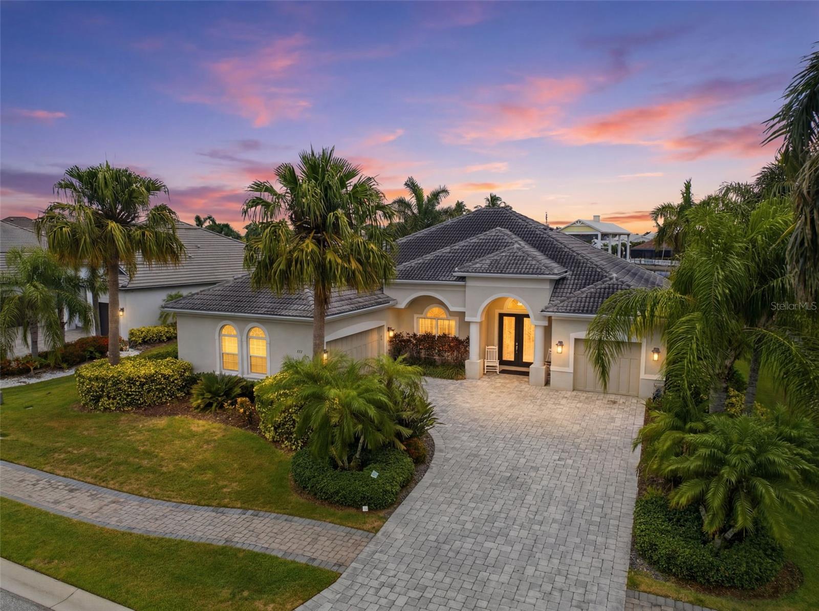 Boasting direct, deep-water access to the Gulf, this exceptional three-bedroom waterfront estate delivers the ultimate Floridian boating lifestyle. Tucked away in The Reserve, an exclusive, double-gated enclave within Harbour Walk, the property balances privacy with premier coastal living. Out back, a masterfully equipped extended dock serves as your private marina, featuring a boat lift, dual jet ski lifts, a fish-cleaning station, shore power, water, and accommodations for oversized vessels with up to a 5’ x 5.5’ draft. Inside, an award-winning open floor plan creates an immediate sense of breezy sophistication. Soaring ceilings with intricate tray and coffered detailing pair seamlessly with custom built-ins, designer lighting, and polished porcelain tile. The gourmet kitchen features solid wood cabinetry, premium stainless steel appliances, and stone countertops that wrap into a welcoming breakfast bar. Enjoy formal dinners in the adjacent dining room, or sip morning coffee in the casual breakfast nook while watching the boats pass by. The main wing hosts a spacious primary suite, complete with a custom closet, private sitting area, and direct lanai access. For the remote professional, a dedicated den offers a quiet office workspace that can easily transition into a fitness studio, media lounge, or private bonus room, all while opening directly to the outdoor breeze. The screened lanai transforms the backyard into an all-season resort, hosting a full outdoor kitchen, a covered living area, and a sparkling pool. A full-house generator offers ultimate peace of mind during Florida’s storm season. Located just minutes from Interstate 75, this estate provides effortless access to the entire Gulf Coast, including premier shopping, fine dining, some of America’s most awarded beaches, and three major airports. Call today to schedule your private showing!