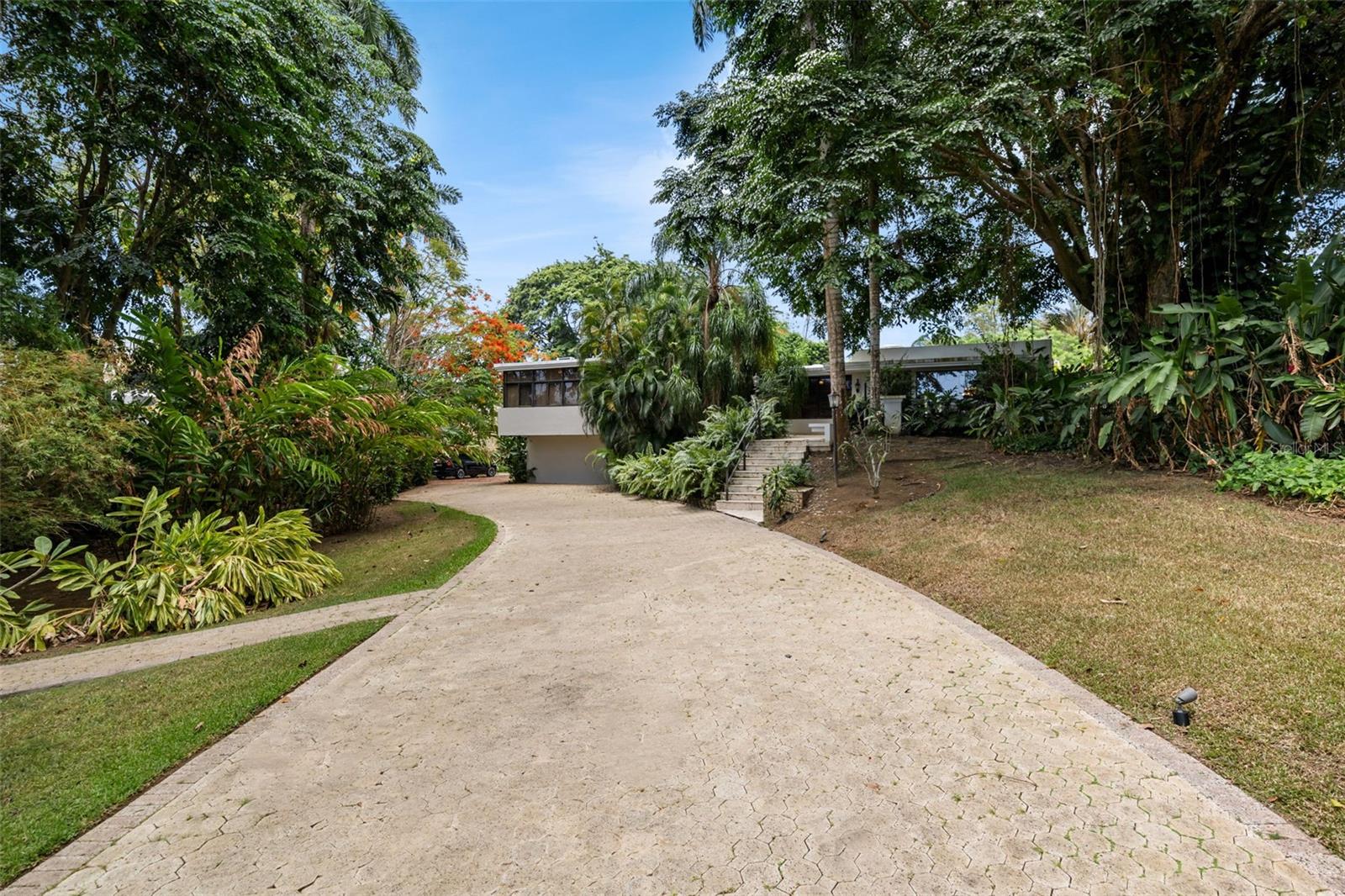 Welcome to 1841 Begonia Street, the finest homesite currently available for sale in Santa María! Surrounded by mature tropical landscaping, this private estate embodies the essence of refined Caribbean living, where timeless architecture, resort-inspired amenities, and modern infrastructure come together in one exceptional residence.

Encompassing approximately 7,913.60 square feet – 4,027 interior sq/ft and 3,886.6 exterior sq/ft of resort-like amenities – the home is thoughtfully designed for both grand entertaining and everyday comfort. To top it off, it sits on a unique 5,403.47 square meters lot. Terrazzo floors lend warmth and character throughout much of the interior, while expansive windows and glass doors invite natural light and create a seamless connection between the elegant living spaces and the lush outdoor environment. The result is an effortless indoor-outdoor lifestyle that defines luxury living in Puerto Rico.

Multiple formal and informal living and dining areas accommodate everything from intimate family gatherings to large-scale entertaining, while the three-bedroom suites provide a peaceful retreat from the home's social spaces. An interior powder room and dedicated outdoor pool bath provide added convenience for residents and guests alike.

At the heart of the estate lies a spectacular heated saltwater pool, completed in January 2023 and surrounded by generous terraces designed for lounging, al fresco dining, and entertaining beneath the Caribbean sky. Framed by mature tropical gardens, the outdoor living experience evokes the atmosphere of a private resort while offering exceptional privacy.

The kitchen, renovated in Summer 2022, features premium Nolte Küchen cabinetry, porcelain and granite countertops, and a curated suite of Monolith, BOSCH, and Frigidaire appliances. Modern comforts continue throughout the property with remotely controlled Pentair systems for the heated pool and spa, 56 solar panels, a 40-kW diesel backup generator, and a 500-gallon water cistern, providing efficiency, resilience, and peace of mind.

Perhaps one of the home's greatest luxuries is its versatility. While the principal living spaces are timeless in their design and provide a 3-bedroom wing, the expansive lower level presents a remarkable opportunity for personalization. Whether envisioned as additional bedrooms, a private wellness pavilion, professional-grade fitness studio, cinema, executive office, wine cellar, collector's gallery, additional garage for prized automobiles, or an exclusive entertainment lounge, the space offers limitless possibilities to reflect the lifestyle of its next owner.

Santa María is one the most exclusive residential communities in San Juan and is defined by privacy, security, and enduring value. Multiple controlled-access entrances place residents just minutes from Puerto Rico's premier schools, hospitals, business districts, fine dining, luxury shopping, and vibrant entertainment. Here, the convenience of city living is seamlessly balanced with the tranquility of a private estate.

1841 Begonia Street is more than an exceptional residence—it is a rare offering within one of Puerto Rico's most coveted neighborhoods, thoughtfully designed for those who value privacy, timeless elegance, and an uncompromising standard of living. Call today to schedule your showing!