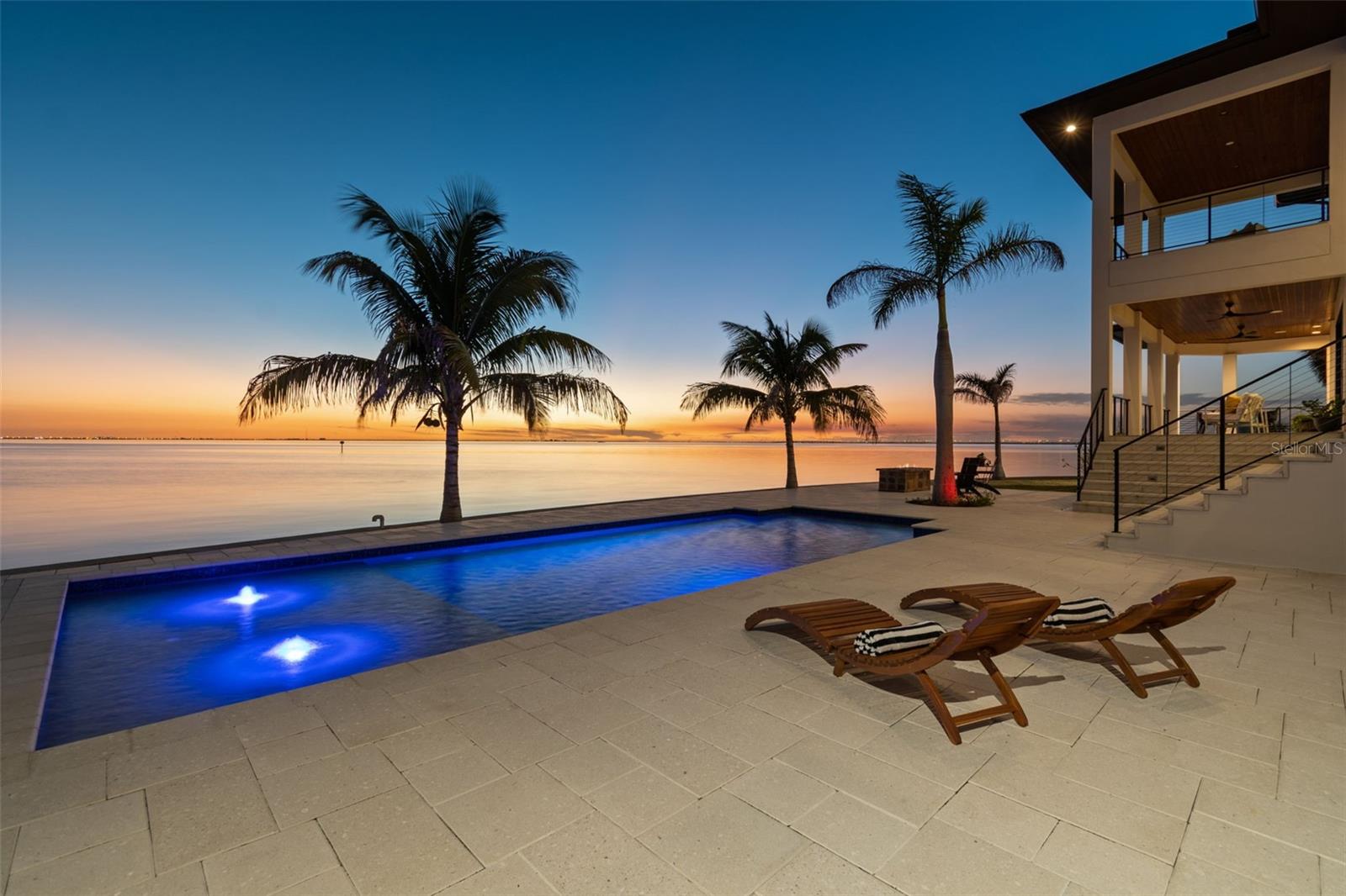 Welcome to the prestigious waterfront enclave of Sunset Park Isles in South Tampa, where luxury living meets panoramic perfection. This exquisite custom-built residence, completed in 2022 graces the tip of one of the most coveted streets in all of South Tampa, boasting an unrivaled 196 feet of awe-inspiring Open Bay views. Meticulously designed and built by one of Tampa's finest, Devonshire Custom Homes, this home is a true sanctuary seamlessly blending relaxation and luxury, all while showcasing the captivating vistas of Tampa Bay. Why wait 3 years to build when you have this rare opportunity to acquire a recently constructed masterpiece on the finest waterfront lot in this highly sought-after neighborhood offering breathtaking Open Bay views and deep-water dockage. The sunsets and waterfront are incomparable! As you step through the pivot-style entry door you will be enchanted by the thoughtful craftsmanship that has been woven into every corner of this home. Double-volume ceilings and rich wood floors create an ambiance enhanced by the water's edge and timeless sophistication. This gorgeous home boasts 5 bedrooms and 4 full baths, plus 2 thoughtfully placed half baths including one that services the outdoor kitchen and dining area, as well as poolside. The heart of this home resides in the chef's state-of-the-art kitchen, meticulously designed with top-of-the-line appliances, including a Sub-Zero Refrigerator and a Wolf Range with double ovens and complemented by exquisite Cambria countertops. No detail was overlooked in creating this culinary haven. Another fantastic design element is the stunning first floor owner's suite, offering sweeping open bay views through expansive windows, a separate sitting area with doors leading to the terrace overlooking the beautiful pool. In addition, it features a luxurious modern bath, and a custom walk-in closet that will satisfy even the most avid shopper. Embrace the Florida lifestyle in the exceptional outdoor living and dining area with a full kitchen, island with room for plenty and a convenient half bath. The designer saltwater pool, elegant pavers, and private dock are a testament to the captivating allure of waterfront living—breathtaking sunsets grace every corner of the huge backyard and almost all rooms inside. The dock exceeds expectations, measuring 14ft x 12ft, complete with a lift rated for 12,000 lbs. and constructed using "Weardeck" composite for lasting durability.  Entertainment is elevated with a dedicated AV room, meticulously designed with a surround sound system zoning for specific areas, ensuring an unparalleled audio experience. An elevator, pre-wired for easy installation, adds convenience to this well appointed residence. The three-car split garage offers ample space for your vehicles and is pre-wired for an electric charging station and lifts catering to car enthusiasts. The property boasts an advanced irrigation system with eight zones, ensuring lush landscaping year-round. Even your four-legged family members are considered, featuring a convenient dog washing station with the best water views in town in the generously sized laundry area.  Don't miss this exceptional opportunity to elevate your lifestyle and make this home your own. Additional highlights of this extraordinary property include a whole house solar system connected to the TECO grid for practically $0 electric bills.  Discover the South Tampa lifestyle and contact me today for your private showing. Room Feature: Linen Closet In Bath (Primary Bedroom).