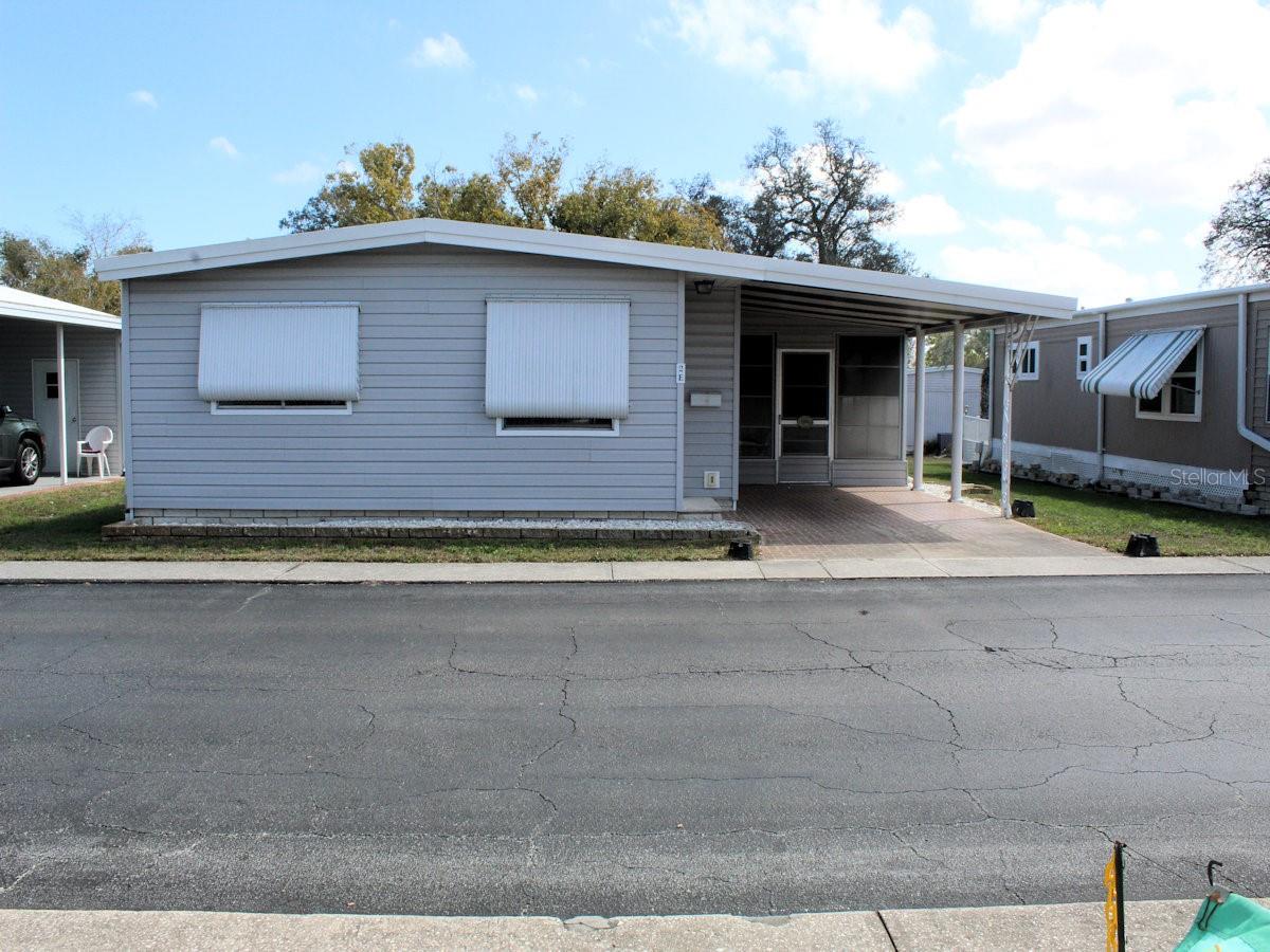 Palm Hill Mobile Home Park is a popular 55+ plus community with many friendly residents. There are
many opportunities to be as active as you wish. From pools, golf, tennis, pickleball, shuffleboard,
dances, and many more opportunities Palm Hill is worth checking out. Within the confines of this resort
like community lies a neat two bedroom, two bath manufactured home ready for new owners. The
home is sold furnished and for a very reasonable price. The floorplan is designed for easy living. Light
crisp paneling and windows spaced throughout the home enhance openness. The furniture remains
while the very reasonable list price gives room for updating. The kitchen has a sink in front of a window.
Refrigerator, dishwasher, stove and counter microwave are situated for comfortable use. The kitchen
opens to the sit-down dining area with a built-in hutch. The hutch has storage drawers below and space
above for displaying trinkets. The dining space is open to the living room beyond. Windows bring
filtered light to the inside. An entrance door at the end of the room opens to the outside. The two
bedrooms are located on the opposite side of the house. The generous size primary lies in the back. It
has built in cabinets and a roomy wall closet. The ensuite bath features shower, vanity and toilet. A full
bath with tub and shower sits between the bedrooms. This creates two separate suites when company
visits. The gray siding with white trim presents a highly attractive appearance. Off the carport there is a
bonus room with vinyl windows that leads into the utility shed featuring a stackable washer dryer plus
storage area. The very reasonable list price includes a share in the community. This fine
home should not last long so please call with questions or to schedule a private showing.