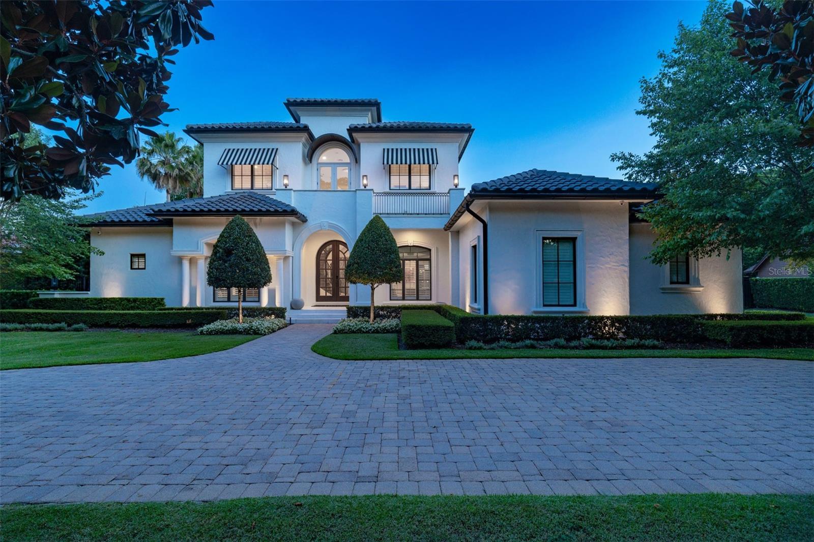 A pristine location in the Vias of Winter Park, this refined Santa Barbara-inspired Mediterranean estate rests on nearly half an acre — a rare double lot. A 2006 custom build by Maroon Fine Homes and renovated in 2024 by Greg Hardwick, this estate blends timeless architecture with comfortable sophistication and functionality. A stone’s throw to the celebrated shops and dining of Park Avenue, Rollins College, Winter Park Golf Course, and the serene beauty of Kraft Azalea Gardens, the location is simply unrivaled.

This extraordinary residence spans nearly 5,000 sf with a flowing floor plan designed for entertaining and everyday living. Solid wood artisan arched doors anchor the inviting foyer with porcelain marble tile, volume ceilings, and a sleek iron circular staircase as a focal point. An open dining and intimate living room layout are flanked by windows and clear view doors, which bring in natural light. The spaces share a unique temperature-controlled wine cellar finished with seamless glass and ambient lighting, adding a dramatic touch for the discerning enthusiast.

The main level centers around a spacious kitchen that enjoys a dedicated eat-in space and counter seating, with a family room that overlooks the expansive backyard. A dedicated wet bar and first-floor bonus room make this home ideal for hosting at any scale.

The outdoor living rivals a 5-star resort, recently reimagined in 2026 by Signature Landscaping. An immense new pool with a sun shelf anchors the outdoor living experience, surrounded by a lush turf courtyard, sport court, and a covered lanai with generous pavered decking and a summer kitchen. A cozy gas fire pit with casual seating invites you to take in the evening breezes. Privacy abounds with mature Japanese blueberry trees and Podocarpus hedges. A dedicated side yard dog run completes this outdoor haven.

The main floor is home to the first-floor primary suite, with privacy doors separating this section of the home. It is a true retreat unto itself, offering a sunlit sitting area with doors leading to the backyard, a beautifully appointed bath, a dedicated home office, and two custom-fitted walk-in closets, one of which includes a secondary laundry area. The spa-inspired bathroom has it all, featuring a generous shower with a soaking tub within the enclosure for the ultimate relaxation experience. A first-floor guest suite, thoughtfully designed with a split-plan layout, provides privacy for visitors, while three additional ensuite bedrooms and a bonus landing are located upstairs.

The oversized three-car side-loading garage is air-conditioned and features upgraded flooring, while a generous circular drive and mature front hedge offer a gracious arrival experience and an added layer of privacy. A rare convergence of premier location, architectural distinction, and meticulous renovation — this is Winter Park luxury living at its finest.