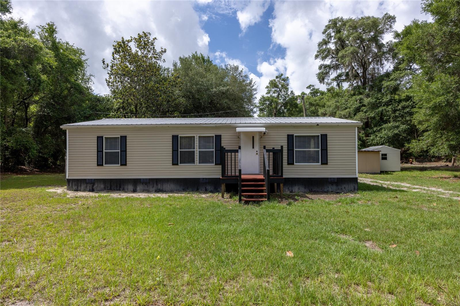 Welcome to this beautifully remodeled 3 bedroom 2 bathroom home situated on 4.5 acres. Nestled in the tranquil neighborhood of Spanish Trace, this serene location offers peace and privacy, making it an ideal spot to settle down and create your own haven. The home was fully remodeled in 2025 with high-end materials and craftsmanship. Step inside to discover a thoughtfully designed layout featuring a spacious living room perfect for both entertaining and relaxing, accented by natural light pouring in through windows. The kitchen features new stainless-steel appliances and ample cabinet storage. Adjacent to the kitchen, a laundry room with plenty of room for a washer, dryer, and extra storage racks. The primary bedroom is spacious and includes a walk-in closet. The primary bathroom has been fully remodeled, with a new vanity and step-in shower. This home has a split floor plan, providing a living room and dining room perfect for entertaining and relaxing. On the other side of the home, there are two additional bedrooms and a fully remodeled bathroom, providing ample accommodation, luxury vinyl flooring, and ample closet space. These additional bedrooms provide versatility for guests. Numerous updates have been made in the last few years, including a full house remodel in 2025: new interior paint, exterior skirting, new vinyl flooring and trim, new HVAC, new fans, stainless steel appliances, and both bathrooms fully remodeled. Additionally, the home has a newer covered metal roof. Outside, revel in the beauty of a fully fenced 4.5 acre property with a repainted back deck and storage shed. The property is mostly cleared land with some trees for added privacy. The property is conveniently located just 10 minutes from downtown Chiefland and 30 minutes from Cedar Key, which offers ample options for dining, shopping, and hospitals. This is a one-of-a-kind property, so call today to schedule a showing!