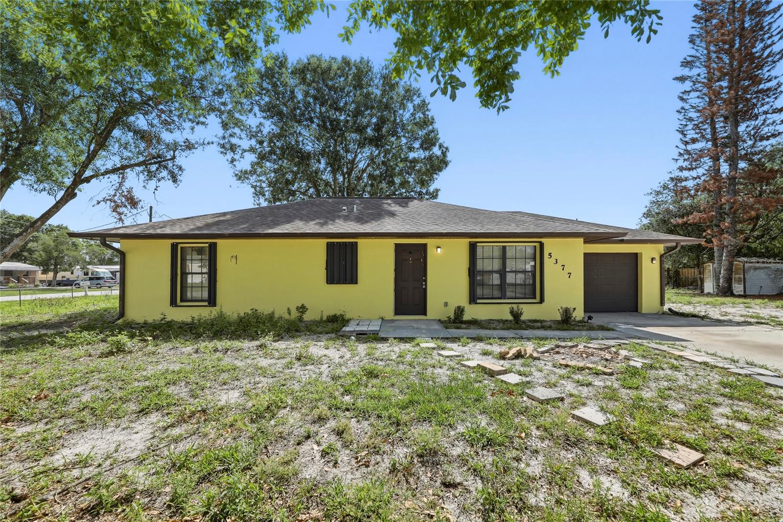 Welcome to 5377 Beck Drive, a beautifully renovated 2-bedroom, 2-bathroom single-family home nestled in Cocoa, Florida. This move-in ready home features fresh interior and exterior paint, updated windows, and vinyl flooring throughout, giving it a clean, modern feel from the moment you walk in. The spacious living room offers plenty of room to relax and entertain, with a sliding glass door that fills the space with natural light and opens to the backyard. The kitchen is well-equipped with warm wood cabinetry, granite-style countertops, and a full suite of stainless steel appliances including a refrigerator, range, microwave, and dishwasher. The generous primary bedroom measures over 15x16 feet and features a walk-in closet and a private en-suite bathroom with a tiled walk-in shower. A second bedroom and full guest bath round out the living space. The attached one-car garage includes a dedicated laundry area with washer and dryer, a water heater, and additional storage space. Situated on a spacious lot shaded by mature trees with a fully fenced backyard, this home offers privacy and outdoor space to make your own. Zoned for Brevard Public Schools and conveniently located near I-95, shopping, dining, and the beautiful Space Coast beaches. No HOA — don't miss this one!
