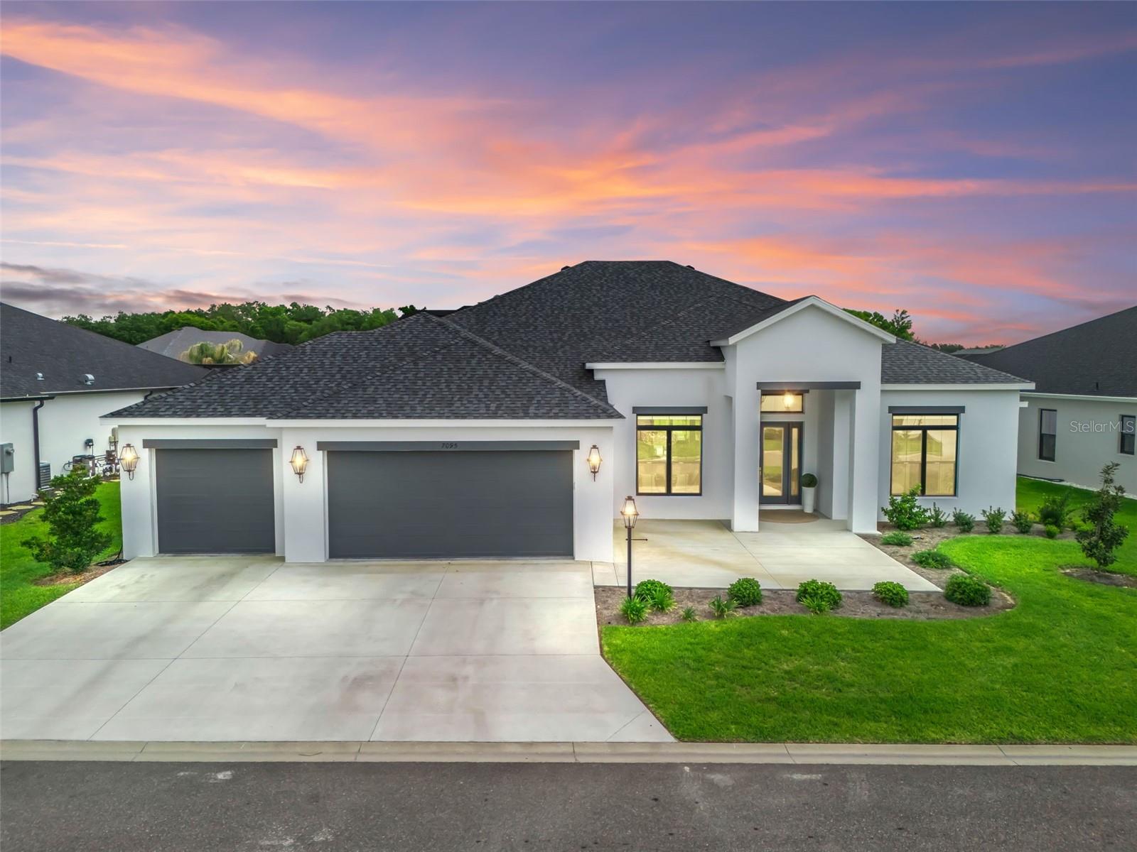 Welcome to Florida refined luxury living in The Villages! This exceptional St. Charles model pool home is perfectly positioned within the Enclave, Village of Dabney, an exclusive area of entirely Premier level homes on oversized lots, with a single private entrance—offering both prestige & peace of mind. Situated on an offset homesite, this property enjoys a combination of open space & privacy, enhanced by surrounding manicured hedges creating a serene & secluded feeling. The home’s grand, elevated entry makes a striking impression, leading into a bright, inviting foyer highlighting soaring 12' ceilings & elegant architectural details. Designed with both everyday living & entertaining in mind, the open-concept layout & unique brushed tile flooring throughout seamlessly connect all spaces of the home. Trey ceilings further elevate the great/dining room. Expansive views & sliding glass pocket doors draw your eye to the stunning outdoor oasis beyond offering the best indoor-outdoor entertaining experience possible. The gourmet kitchen is a true showpiece, featuring an oversized 12'+ island/bar with designer pendant lighting, exquisite quartz countertops, & a full-height cabinet-to-counter backsplash. Outfitted with a premium built-in Thermador stainless refrigerator & wine cooler—along with a GE Profile gas stovetop with custom hood & convection microwave above the wall oven—this space is as functional as it is beautiful. Ample cabinetry & storage ensure everything has its place, complemented by a spacious butler’s pantry with contrasting cabinetry & an additional under-counter wine cooler. With a split layout for the utmost in privacy -- the luxurious primary suite offers a private retreat, complete with dual oversized vanities, a full wall linen cabinet, & stunning walk-in tiled shower. This space includes two expansive master walk-in closets thoughtfully designed with custom built-in organization systems. A fully equipped laundry room adds convenience with abundant built-in cabinetry & a large utility basin.  Two additional guest bedrooms on the opposite side of the home can be separated from the main living area with a pocket door--each features its own full bathroom with beautifully tiled walk-in shower & custom built-in closet organization system. One of the guest bathrooms also offers direct access to the pool & outdoor living area—ideal for entertaining as well. Step outside to your personal resort-style oasis, where a spacious covered lanai with triple ceiling fans overlooks a breathtaking saltwater pool. Designed for relaxation & entertaining, the pool features a tanning ledge, built-in bench seating, & a tranquil waterfall, all finished with elegant tile accents. The entire outdoor space is enclosed within a tall screened birdcage & accented by privacy hedges in the distance, creating an intimate yet open-air retreat. The expanded three-car garage is equally impressive, featuring sealed finished flooring, additional cabinetry, & a dedicated refrigerator. Additional upgrades throughout the home include motorized remote-control window shades, pull-out shelving, under-cabinet & toe-kick lighting, & a screened front entry with 8' double doors. Nearly new & meticulously maintained, this extraordinary home constructed of block exterior walls, offers the perfect blend of luxury, comfort, and thoughtful design—all within one of The Villages' few, and newest, desirable Premier neighborhoods. Select furnishings may convey separately.