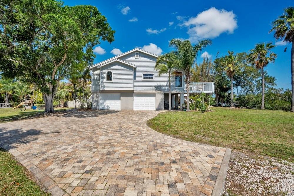 Experience the laid back lifestyle of Oldsmar, a sought-after community nestled between the urban hubs of Tampa and Clearwater. This serene, waterfront property offers the perfect balance of peaceful living and convenient access to local attractions. Residents here enjoy a tranquil, private environment, starting mornings with fresh coastal breezes on a private porch or deck, and spending evenings watching sunsets from a kayak or boat. This elevated, two-story home, topped with a 2025 roof, showcases an expansive layout filled with radiant natural light and soaring vaulted ceilings. The interior ambiance is both airy and welcoming, anchored by a charming wood-burning fireplace. The heart of the home is a sun-drenched, open-concept great room and kitchen, equipped with stainless steel appliances, granite surfaces, a propane stove, and a tankless water heater, all showcased by floor-to-ceiling windows. The generous primary suite acts as a private retreat, featuring an ensuite bathroom with a garden tub, dual vanities, and a separate shower, alongside a private deck offering stunning vistas. Functionality meets flexibility in the lower level, which houses a spacious two-car garage and a versatile 600-square-foot accessory dwelling unit. With its own entrance, bathroom, and kitchen facilities, this suite is perfectly suited for guests or extended family. The exterior features substantial paver parking, ready to accommodate RVs, boats, and other recreational vehicles. Nature enthusiasts will delight in the local wildlife, including dolphins and manatees, viewable directly from home. The property’s private floating dock and boat ramp provide effortless access to Tampa Bay without worrying about the tides. Elevated construction ensures peace of mind during inclement weather, while the property’s location—situated on a private, oversized lot on a quiet cul-de-sac—secures absolute seclusion. Located in a premier school district and just 20 to 30 minutes from the region’s best beaches and downtown centers, this home also offers residents easy access to the festive R.E. Olds Park and the vibrant dining scenes of nearby Safety Harbor. Both Mobbly Beach Park and the picturesque Phillippe Park are situated within a three-mile radius, making them a breeze to reach via cycling or boat. Oldsmar stands out for several unique reasons: it operates its own reverse osmosis water filtration system, houses the Tampa Bay Skating Academy Ice Rink, and maintains a higher density of parks per square mile than any other municipality in the state, with roughly 40% of its total area reserved for green spaces and conservation. Those who love the outdoors can take advantage of the ten-mile Oldsmar Trail, which winds through eight of the city's ten parks, providing endless chances for recreation and immersion in nature. Don't wait—secure your chance to live out your ideal Florida dream by booking your private viewing of this exceptional property today!