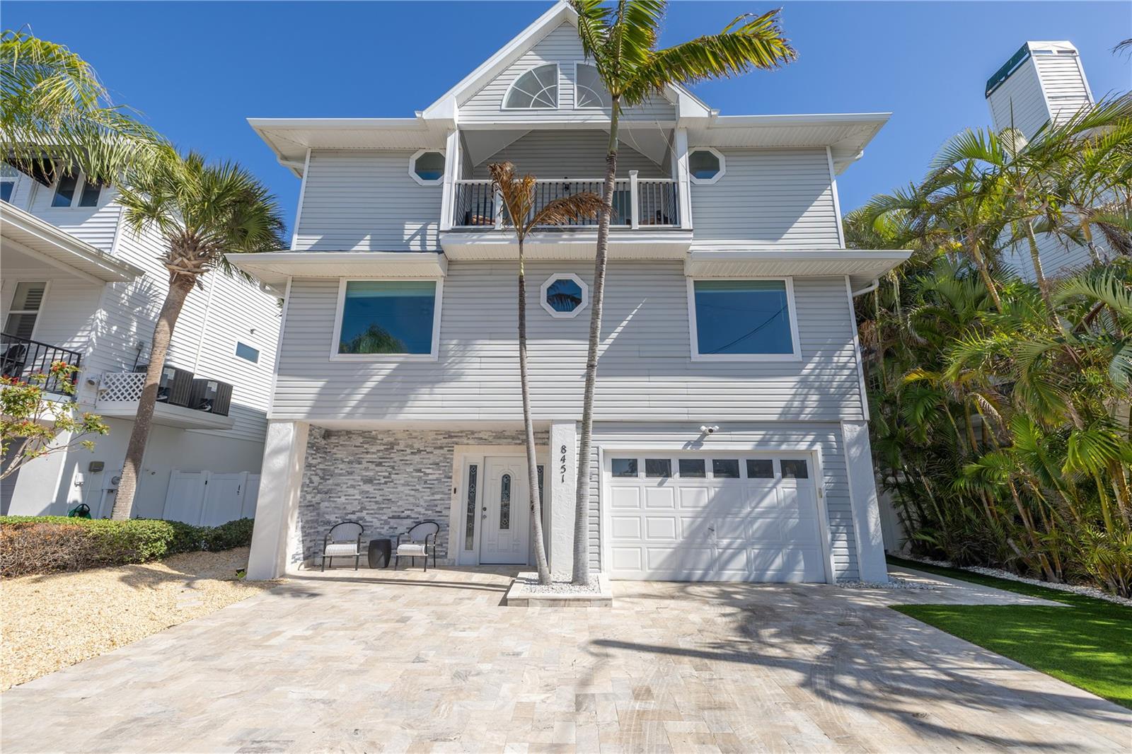 Come home to stunning Sunset Beach and enjoy the vacation lifestyle in this beautifully renovated waterfront residence.   Location is everything in this ideally situated home, with wide water views of Blind Pass and only a few short steps to beach access and the Gulf of Mexico.   This impeccably maintained property provides resort style comfort and impressive upgrades and conveniences throughout.  The kitchen boasts new attractive white shaker-style cabinetry, quartz counter tops, sleek black stainless appliances and a 5 burner gas cook top. All bathrooms have a luxurious spa-like comfort with elegant new fixtures, tile accents and lighting.  The large master suite includes a roomy walk-in closet, private bath and a balcony - the perfect spot to relax with morning coffee. There's also a convenient laundry room that is accessed from the 3rd floor guest bath. Brand new impact rated windows and sliding doors were just installed. This spacious home is perfect for entertaining guests and family with 5 bedrooms and a large downstairs bonus room that includes a built-in bar and an adjacent outdoor lanai.  The inviting outside oasis features classic, cool travertine pavers that surround a large beautifully remodeled, heated pool and spa and also an outdoor kitchen.  There's plenty of covered and open deck space for lounging and enjoying breathtaking water views. There is a new seawall and a renovated dock that features a 20,000 pound lift and easy direct access to the Gulf of Mexico.  The oversized garage could hold two cars (tandem) or one car with two jet skis, with additional room still available for storage.  The exterior of the home features tropical landscaping and is nearly maintenance free. Just a short walk to "Caddys" beach front restaurant.  There is also a small ramp close by for launching small watercrafts.   Better hurry if you want to make this exceptional home yours!!