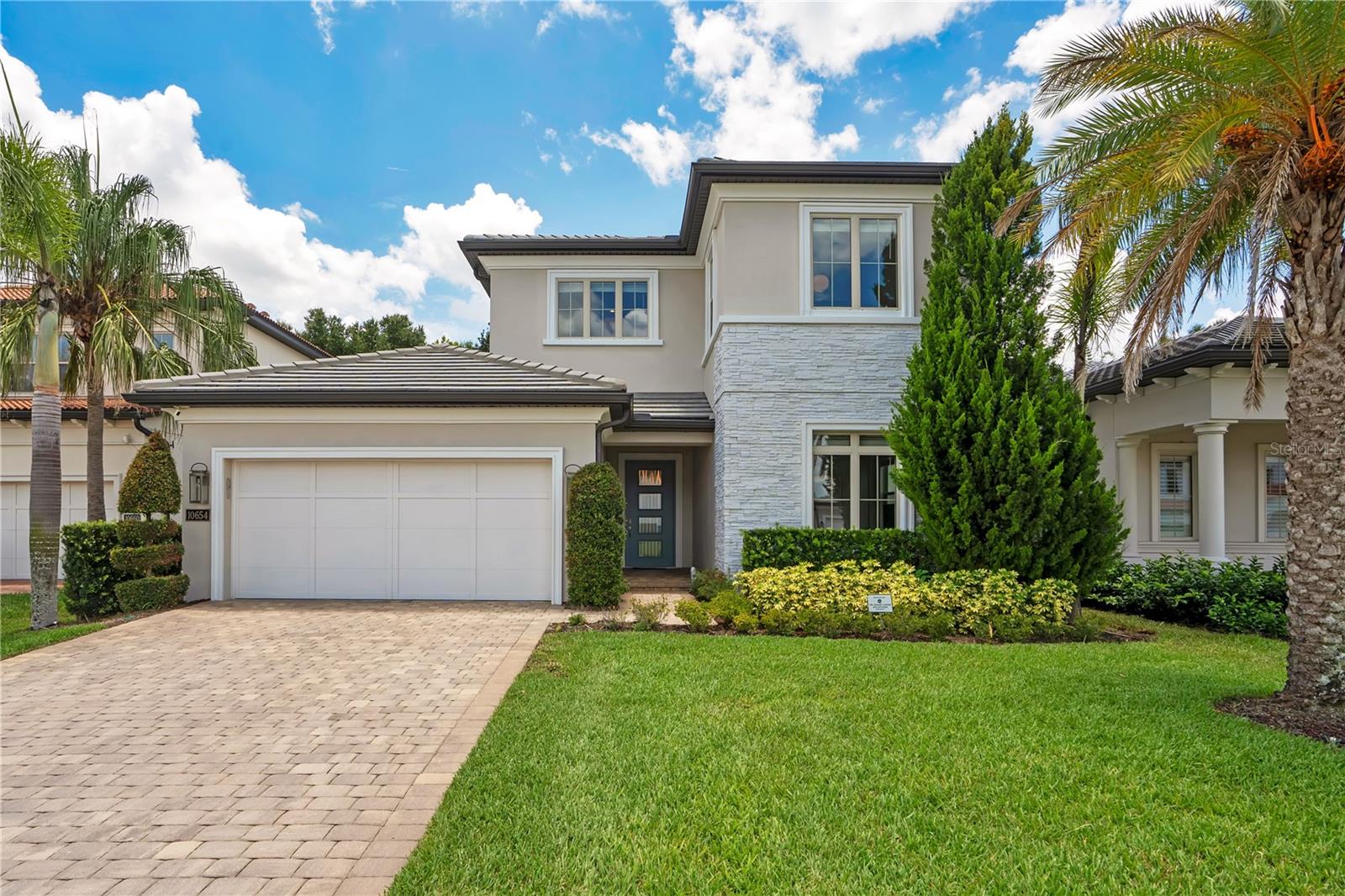 Welcome to an exceptional residence located in the highly sought-after gated community of Royal Cypress Preserve. Built by Toll Brothers and ideally situated just minutes from Walt Disney World and directly across from Evermore Resort, this beautifully upgraded home offers the perfect combination of luxury, comfort, and location.
Designed for both luxury living and effortless entertaining, the home features engineered wood flooring throughout, an elegant wood staircase leading to the spacious bonus room, and beautifully upgraded cabinetry in the kitchen and bathrooms. The gourmet kitchen serves as the heart of the home, showcasing stunning Calacatta quartz countertops with a dramatic waterfall edge and a modern, timeless design.The exceptional indoor-outdoor living experience is enhanced by extended lanais finished with rustic French-pattern travertine pavers, a summer kitchen with quartz countertops, and automated privacy screens for added comfort and versatility. An automated sheer-weave screen complements the pocket sliding glass doors, allowing the living spaces to seamlessly transition to the outdoors.

Technology and entertainment have also been thoughtfully integrated throughout the residence, featuring three high-end 5.1 home theater systems and Sonos sound in the living room, lanai, primary bedroom, and bonus room.

The bathrooms continue the home’s elevated design with upgraded cabinetry and quartz countertops. Every detail has been carefully selected to create a beautiful and comfortable living environment.

Offering exceptional upgrades, beautiful indoor-outdoor spaces, and an unbeatable location near Orlando’s world-class attractions, dining, shopping, and entertainment, 10654 Royal Cypress Way presents an outstanding opportunity to experience luxury living in one of Central Florida’s most desirable gated communities.