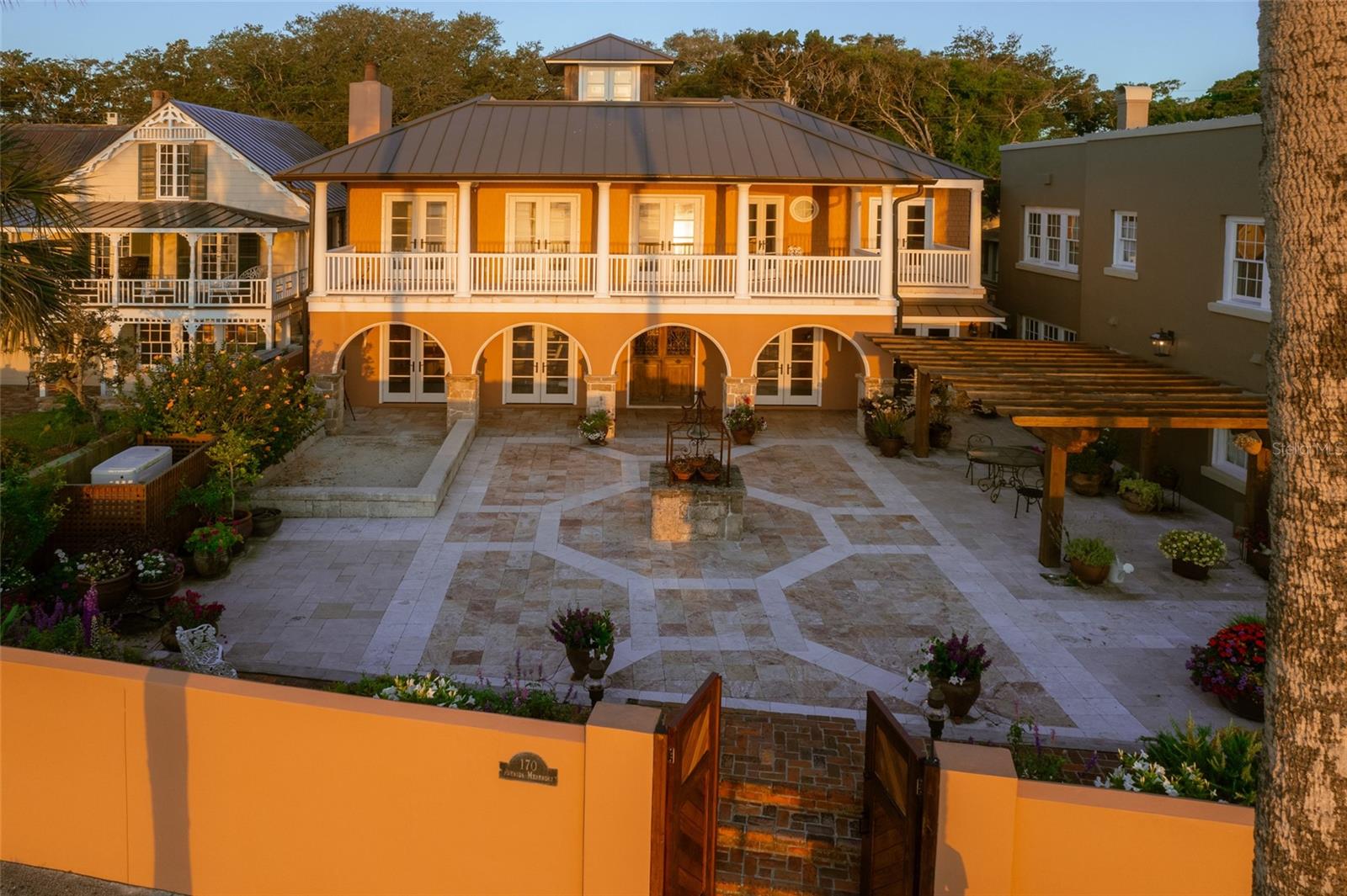This home in Historic St. Augustine Florida, is a captivating address nestled in the city's historic district. Rich history and cultural heritage, this charming property embodies the timeless allure of America's oldest city, founded in 1565. Upon entering, you are welcomed into a world of elegance. The interior spaces are meticulously appointed with luxurious finishes and thoughtful details, creating an inviting ambiance throughout.The foyer sets the tone for the rest of the home, featuring a grand entry door that dates back 300 years from France. Crafted from Wormy Chestnut wood and adorned with original hardware and decorative wrought iron gridwork, a true masterpiece of craftsmanship. Flagstone flooring, coquina walls, and antique beamed ceiling further enhance the historic charm. The main hall features a classic half bath with High-Tank Toilet and Copper sink mounted to a custom reproduction furniture vanity. The living room, a cozy retreat, complete with an oversized gas fireplace with a surround imported from Manchester, England and reclaimed yellow pine flooring. French doors lead to an outdoor courtyard with breathtaking views of the bay, blurring the lines between indoor and outdoor living.
The elegant dining room features antique shutters made of wormy chestnut and a limestone fireplace surround imported from England. An antique oxen yoke chandelier, recessed lighting and the 8-inch oak baseboard trim add ambiance. The kitchen, a chef's dream, boasts custom cabinets and an island crafted by a local wood craftsman, leathered granite countertops, and Heartland premium appliances. The adjoining laundry room offers top-of-the-line LG washer and dryer. Garage houses Generac generator control panel. The primary bedroom offers three sets of French doors to a covered veranda with limestone floor overlooking the bay. The ensuite bath features marble flooring, two porcelain console sinks, and a porcelain soaking tub, creating a spa-like oasis. Ensuite bedrooms offer comfort and privacy for guests, each with upscale finishes, fireplaces and modern amenities. The third-floor features a private roof top terrace with incredible views of the Bay.