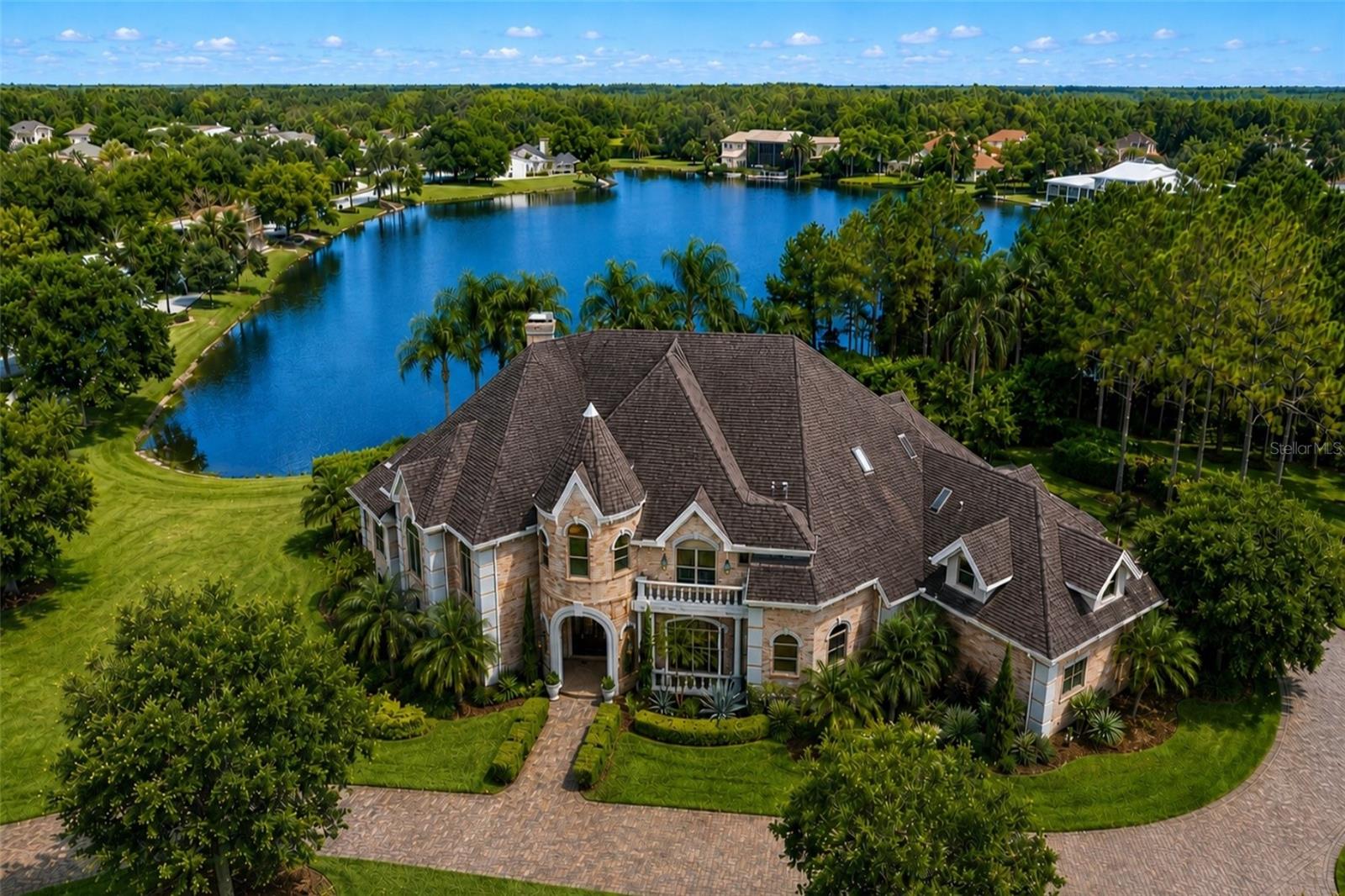 One or more photo(s) has been virtually staged. Distinctively detailed and masterfully crafted, this exceptional Alvarez built estate showcases timeless elegance, extraordinary workmanship, and luxury finishes throughout. Situated on a premier corner lot of approximately one acre with beautiful lake views, this one of a kind custom residence offers an unmatched blend of sophistication, scale, and functionality. A dramatic two story gallery entry welcomes you with a sweeping staircase, marble flooring with decorative insets, and impressive architectural detail throughout. The gracious formal living room features a granite fireplace with custom cherry mantle, while the oversized formal dining room is ideal for entertaining on a grand scale. The gourmet kitchen is appointed with Wood Mode cabinetry, granite countertops, stainless steel appliances, and a convenient butler's pantry.
The private cherry paneled study creates an elegant executive workspace, while the expansive family room offers built in entertainment features and custom ceiling treatments. Upstairs, a secondary staircase leads to generously sized bedroom suites, each featuring its own private en suite bathroom, creating exceptional comfort and privacy for family members and guests alike. Several suites also offer sitting areas, while additional highlights include a walk in cedar closet and a rare 230 square foot air conditioned mechanical room. The luxurious primary suite includes a private walled sunning area complete with its own outdoor shower. Additional highlights include a dedicated home office/library, oversized fitness room with wet bar that could easily serve as a media room, outdoor kitchen, and stunning central waterfall feature. A new roof was installed in 2019. The expansive backyard offers ample space for a future swimming pool and outdoor resort style design.

Please note: One or more photographs have been enhanced using AI technology and/or virtual staging for marketing purposes. Enhancements may include landscaping, lighting, cosmetic improvements, or visualization of potential features. The swimming pool shown in certain marketing materials is a virtual rendering only. No swimming pool currently exists on the property.

This is a rare opportunity to own a truly unique custom estate where quality, character, and craftsmanship are evident at every turn. A joy to show and certain to impress even the most discerning buyer.