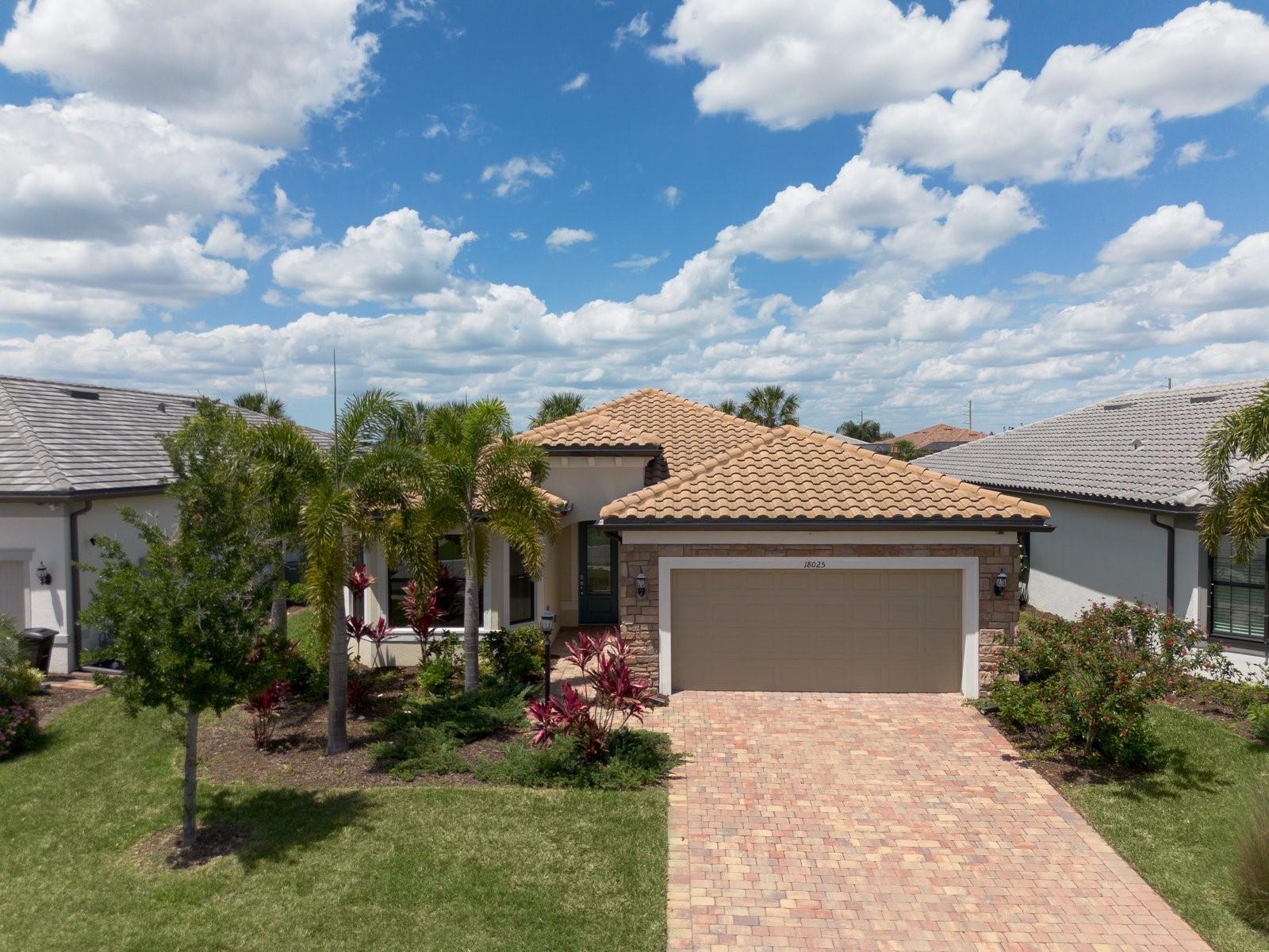 Virtually Staged. Experience the pinnacle of Florida resort living in this stunning, nearly-new Mystique Model located on a quiet cul-de-sac in the prestigious Del Webb Lakewood Ranch. Built in December 2022 and meticulously maintained with only occasional visits, this residence offers 2,128 sq. ft. of pristine, move-in-ready luxury.

From the moment you arrive, the upgraded stone facade and decorative glass front door provide exceptional curb appeal. Step inside to find an interior defined by elegance and volume, rounded corner interior walls, featuring 8-foot interior doors and crown molding throughout the entry, den, dining area, gathering room, and all bedrooms. The flooring is a sophisticated blend of luxury vinyl plank in a light, warm wood tone and large neutral beige tile set on a diagonal for a custom, high-end feel.

This rare configuration is a standout in the community, offering 3 bedrooms and 3 bathrooms, plus a versatile office/den. The gourmet Chef’s Kitchen is a culinary masterpiece, featuring 42” white cabinetry with soft-close drawers, a custom wood hood vent, and solid surface countertops. The space is tied together with a decorative full-tile backsplash, a built-in oven and microwave, a gas cooktop, and a premium KitchenAid appliance package.

The gathering room serves as the heart of the home, featuring zero-corner pocket sliding doors that disappear to create a seamless transition to your outdoor oasis. Step out onto the expanded lanai to enjoy your private saltwater pool with a gas heater and a bronze enclosure, all overlooking a serene water view. The lanai is fully prepared for your dream outdoor lifestyle with pre-plumbing for a summer kitchen (water, gas, and vent) and pre-wiring for television.

The Owner’s Suite is a peaceful retreat boasting a tray ceiling with crown molding and a spa-like ensuite. The frameless glass shower features neutral tile to the ceiling, a built-in niche, a bench, and a window for natural light. Two additional guest rooms—one featuring a charming bay window—and two additional full baths ensure plenty of space for family or visitors.

Practicality meets luxury in the laundry room, which is fully equipped with cabinets on both sides and a sink. The 2-car garage features an epoxy floor coating and a Wi-fi-enabled opener.

Why wait for a new build when you can own this upgraded, never-lived-in masterpiece today? Located in the heart of Lakewood Ranch, the nation’s #1 multi-generational community, you are minutes away from world-class dining, shopping, and the exclusive amenities of Del Webb. Schedule your private showing today!
