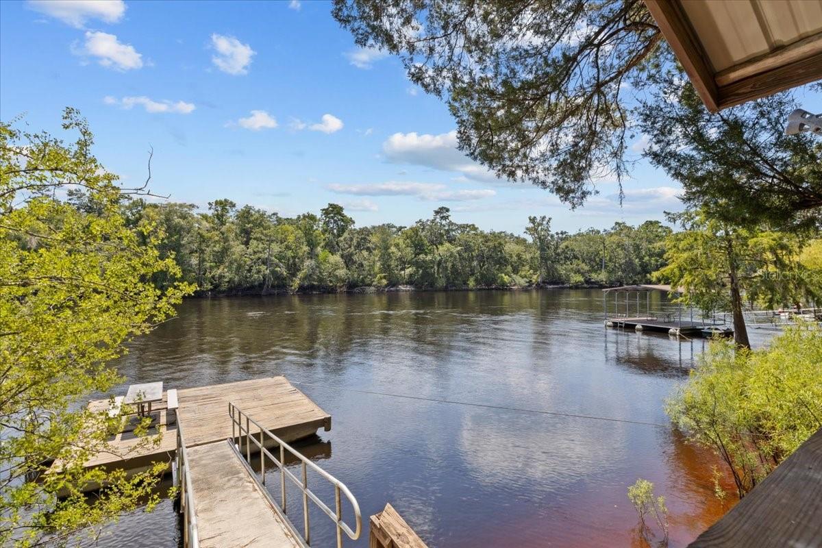 PERFECT LOCATION....SITTING ON THE BANK OF THE SUWANNEE RIVER only 1/4 mile from the confluence with the SANTA FE RIVER making easy boat rides to several springs and the Ichetucknee River. Also navigable to the Gulf of Mexico to the south. This 3 BD/ 2 BA home is situated on a high bank on 1/2 acre with a concrete block SEA WALL along the 100 ft of river frontage! This is a rare find! At the top of the bank is also a covered deck and steps going down to a floating dock. The home is placed on the lot so that you see WONDERFUL VIEWS of the river from the family room picture windows. The large home (1959 sf) has an open concept living, dining, kitchen floor plan with split plan bedrooms. This kitchen has cabinets galore and a breakfast bar. The dining area boasts a built-in display cabinet with additional storage. In addition to the large, comfortable living room, there is a family room with large windows that face the river and also lead onto a covered porch where you can also sit in the hot tub or just lounge and enjoy wonderful views of the relaxing river and back yard. Don't miss fun on the river the rest of the summer! Call soon to set up your viewing of this amazing property!