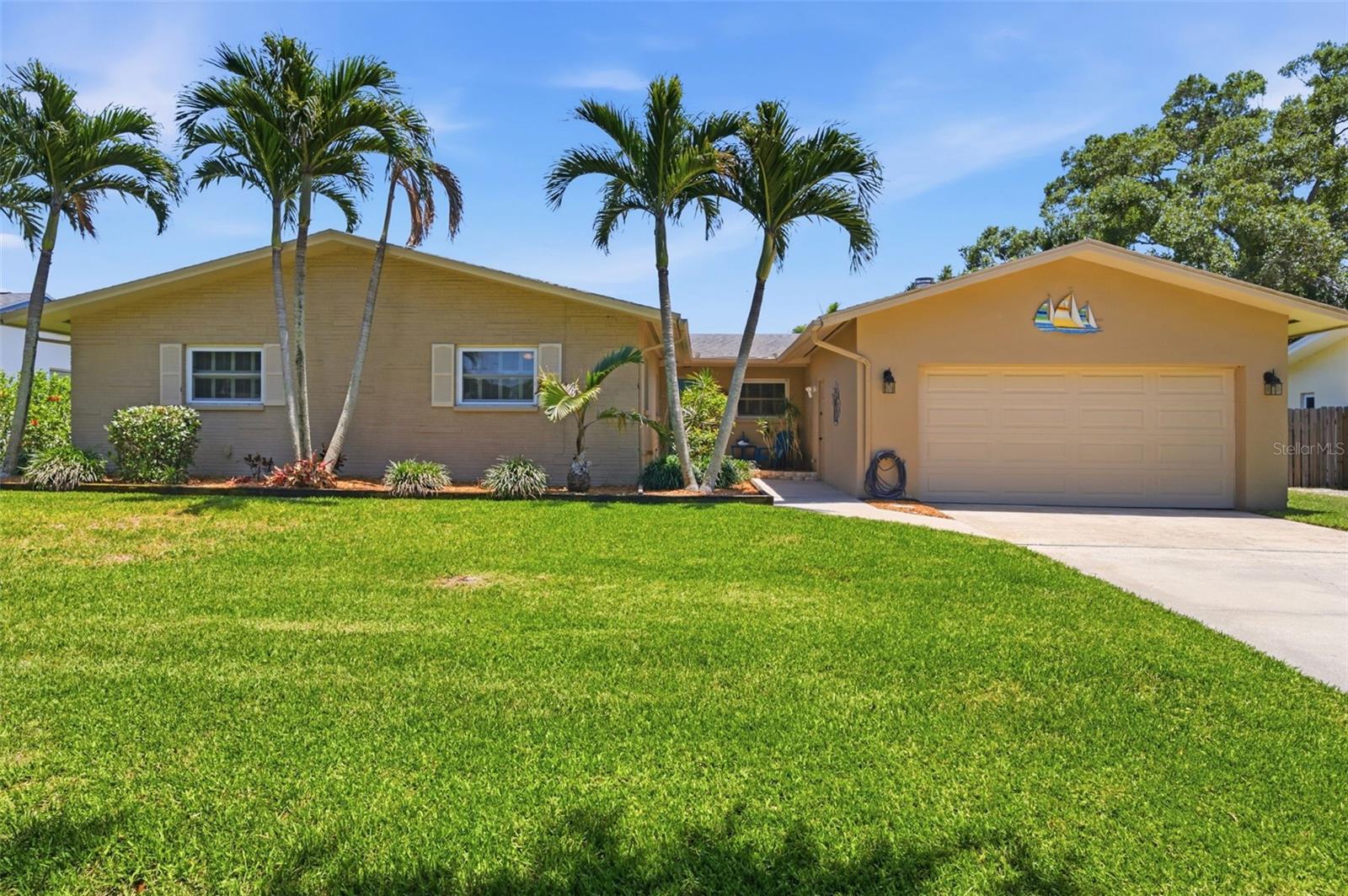 HIGHEST AND BEST OFFERS DUE TO LISTING AGENT BY 5:00 PM FRIDAY 6/26/26 Waterfront living with NO flood insurance required! Welcome home to this beautifully maintained 3-bedroom, 3-bath pool home with screened lanai on a spring fed lake. The updated kitchen features quartz countertops, farm sink, well-designed cabinetry, stainless steel appliances, and a double oven. Luxury vinyl and laminate flooring throughout the home is easy care for the Florida lifestyle. Bedrooms are bright and spacious and the oversized family room with wood burning fireplace could easily be utilized as a fourth/primary bedroom, media room, or home business space. Additional features include a pool bath, outdoor shower, indoor laundry room, oversized two-car garage, and ample closets and storage space. Large updated windows throughout the home bring in abundant natural light and the sliding glass door to the covered patio and pool allows for plenty of room for indoor/outdoor entertainment.  The lush tropical landscape includes palm trees, privacy hedge, and even your own mango fruit tree!  Whether enjoying your morning coffee, entertaining guests, or relaxing poolside, this home embraces a carefree lifestyle. Recent improvements include updated kitchen, vinyl flooring, pool resurfacing/tiling, new pool pump and filter. Located on a lovely tree lined street and just minutes from award-winning Gulf beaches, shopping, and dining, you'll enjoy the perfect combination of convenience and Florida living!