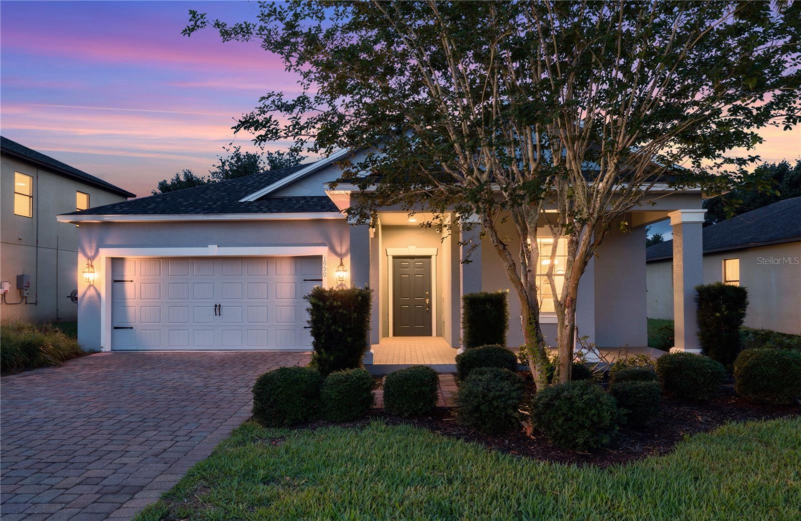 Virtually Staged. Welcome to 1950 Pantheon Drive, a charming 3-bedroom, 2-bath home located in the desirable Alexander Ridge community of Winter Garden. Offering 1,769 square feet of living space, this thoughtfully designed split-bedroom floor plan provides comfort, privacy, and easy everyday living. From the moment you arrive, the home makes a welcoming first impression with a bright exterior, paver driveway, covered entryway, mature landscaping, and a large front tree that adds shade and curb appeal. Inside, the open living, kitchen, and dining areas create a functional flow for relaxing, gathering, and entertaining. The living room features warm engineered wood flooring, neutral tones, and natural light from multiple windows, creating a bright and inviting main living space. The kitchen overlooks the living area and features granite countertops, warm wood cabinetry, stainless steel appliances, pendant lighting, recessed lighting, a breakfast bar, a center island, a deep kitchen sink, and a modern pull-down faucet.  Just beyond the kitchen, the dining area provides a dedicated space for meals while remaining connected to the heart of the home. The private primary suite offers neutral tones and direct access to the ensuite bathroom. The primary bath features dual sinks, granite countertops, warm wood cabinetry, upgraded lighting, a walk-in shower with a glass enclosure, a separate soaking tub, and direct access to the walk-in closet. The walk-in closet also includes convenient door access to the laundry room, adding a smart everyday function. Bedrooms 2 and 3 are located on the opposite side of the home and share a spacious second bathroom. Recent updates include HVAC replaced in August 2024, Solar Panels in 2018, roof installed in 2023. The solar system is paid off, helping create an energy-efficient home with low-cost utilities. Alexander Ridge offers inviting community amenities, including a resort-style pool with paver decking, lounge areas, a covered pavilion, playground, open green space, and beautifully maintained common areas surrounded by mature landscaping and palm trees. This Winter Garden home blends comfort, function, efficiency, and community living in one inviting package.