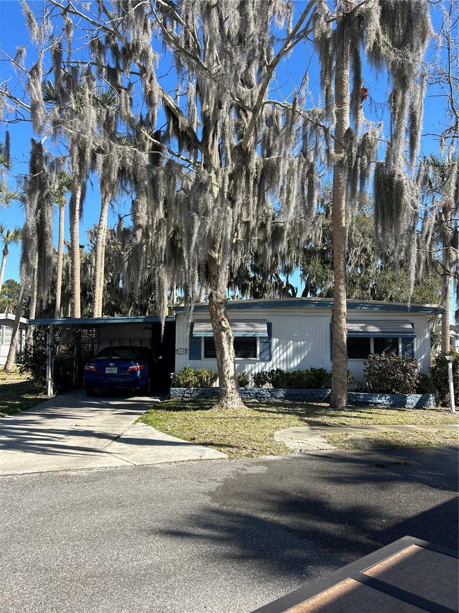 Location, location, location! Enjoy Florida living in this 2 bdrm, 2 bath home in one of the most sought after 55+ retirement communities. Country Club Manor sits on Trout Lake and is convenient to shopping and all other amenities.   Situated on a dead end street, this home is surrounded by two sides of water on a canal leading to Trout Lake. Enjoy your morning coffee on the enclosed porch overlooking the canal. Lots of windows afford the opportunity to enjoy the wildlife that abounds.  The low maintenance fee of $243 includes water, sewer, trash and access to the clubhouse and pool.  This community is a co-op and this lot does own a share.