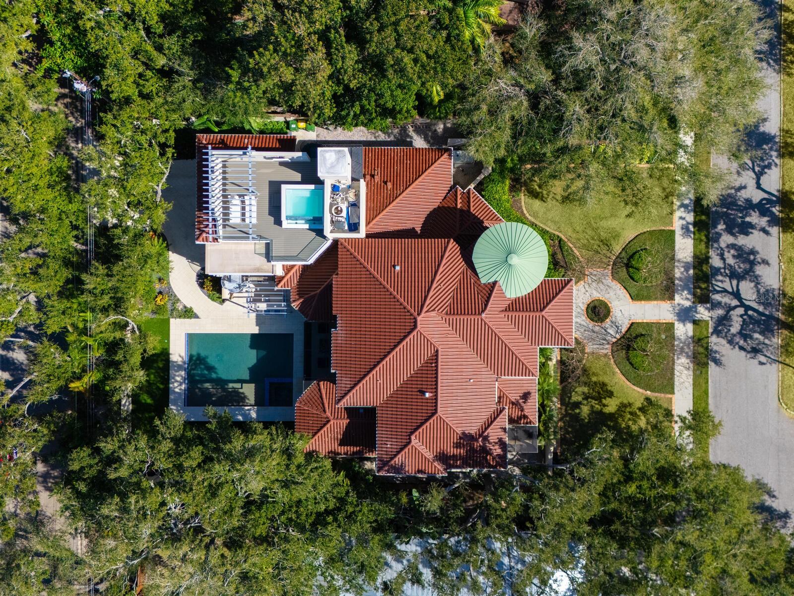 One or more photo(s) has been virtually staged. In Sarasota's desired West of Trail enclave of Cherokee Park, 1655 South Drive, masterfully designed three-story estate where thoughtful architecture meets effortless luxury. Positioned on a homesite that is not in a Special Flood Hazard Area and enhanced with full home hurricane-impact glass and a whole-home generator, this residence offers the rare combination of refinement and peace of mind. Spanning 6,355+ square feet, the home features five bedrooms, five full baths and four half baths, with a layout tailored for grand entertaining and everyday ease. A rear three-car garage, accessed discreetly from South Lodge Drive, preserves the home's striking street presence. Inside, the main level unfolds into a wide-open living experience with a great room with wet bar, formal dining, and a showpiece chef's kitchen outfitted with Wolf dual-oven six-burner range, dual side by side 36” Sub-Zero Over-and-Under Refrigerator/Freezers, a Wolf microwave drawer, a Wolf warming drawer, and built-in Miele espresso machine. The first-floor primary suite is a private retreat, complete with an in-home gym, a spa-inspired bath and dual custom-fitted closets. A beautifully appointed guest suite (fifth bedroom) with en-suite bath also anchors the main level. Access to the upper floors is seamless via a dramatic staircase with custom wrought-iron railings or the private elevator. Upstairs, three additional en-suite bedrooms include custom walk-in closets, one thoughtfully designed with built-in bunk beds, plus a bonus club room with built-in desks and additional laundry for added convenience. Outdoors, the property transforms into a walled and gated resort-style oasis featuring a gas-heated saltwater pool with sun shelf and spa, and an artificial turf lounge/play area. A screened entertainment lounge with a convenient half pool bath connects to a full outdoor kitchen with sink, TV and gas grill, all complemented by a pergola and a mosquito misting system, ideal for Sarasota's seasons. Above the garage, a spectacular casita-style retreat, accessible by the home’s second private interior elevator or exterior spiral staircase, elevates entertaining to an entirely new level with a 2,000-bottle refrigerated wine room, a fully equipped wet bar, mini- fridge, clear ice maker, and dishwasher. Go onto the covered terrace with a gas fireplace, then unwind on the third floor in the private, pool-like infinity-edge spa, an experience that feels equal parts boutique resort and private club. Ideally in walking distance to A-rated Southside Elementary School, Southside Village, Sarasota Memorial Hospital, downtown Sarasota and short drive to the world-famous sands of Siesta Key Beach, this is a rare opportunity to own a bespoke residence in one of Sarasota's treasured neighborhoods.