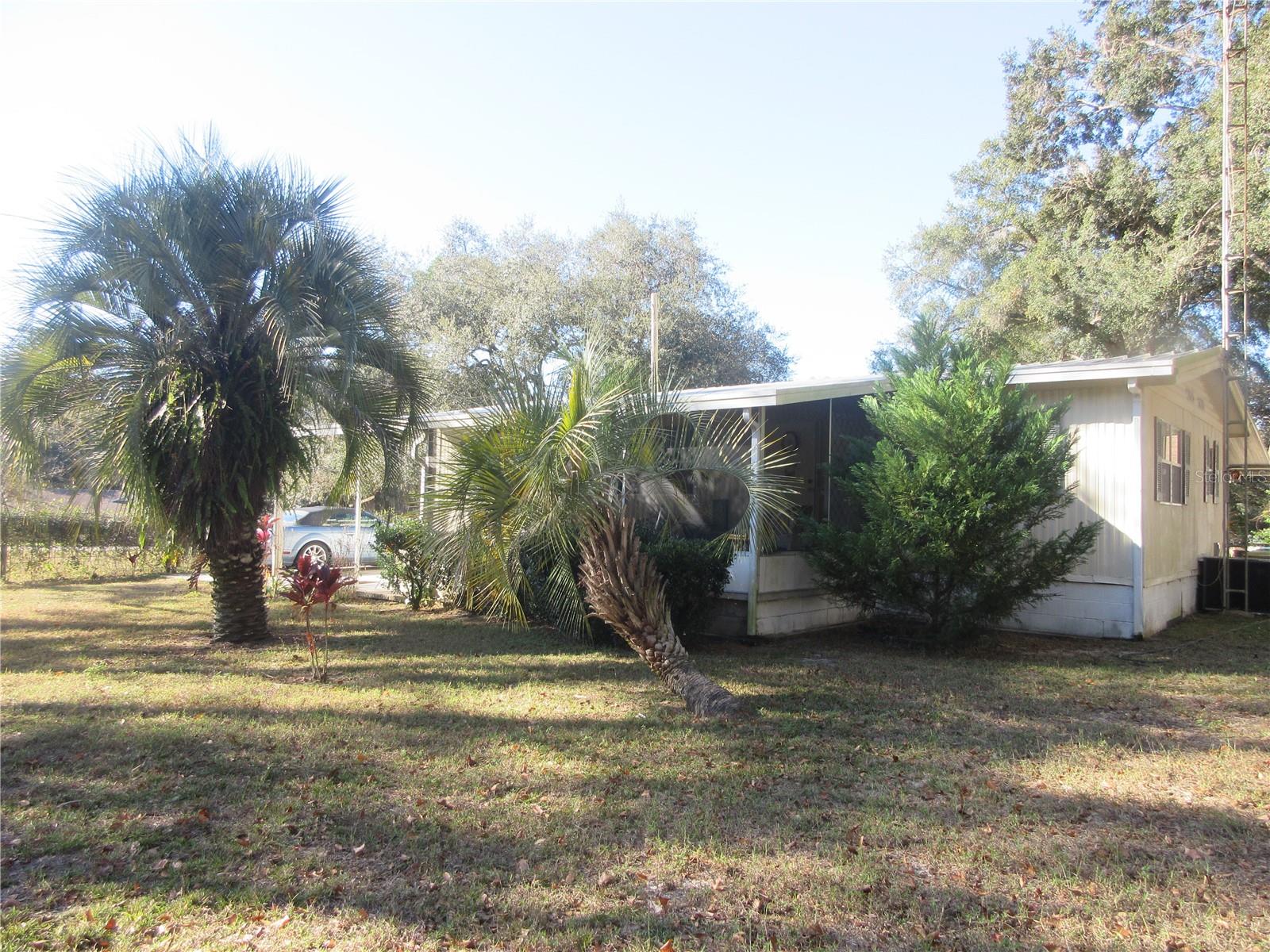 Recently remodeled Lake Access Doublewide Mobile home with garage on a .44 of an acre paved road property! Featuring a well kept 1973 3/1 958 sq ft Doublewide Mobile home. The entire home sits on a footer and concrete block foundation. The roof is a 2005 built up roof with 25 year siliconed roof screws.The central A/C Heat pump and trunk lines are approximately a 2021 model. The unattahced one car garage has both 120 & 240 volt electric with a separate built in removeable utility room partition. Attached is a 3x6 shed and a 6x9 shed. All trees were recently trimmed in 2024. Also included is an 8x10 2023 shed with a second washer and dryer hook up. On the front of the  home is a breezy 10x18 sunrise screened room and on the back is a second 10x20 sunset screen room. The well pump and tank was replaced in 2023 and the drain field replaced in 2014 (pumped in 2023). The 3rd bedroom serves as a laundry room/bedroom combination. The following items were replaced in 2017: Bathroom with fiberglass tub, sheet rock interior walls through out, 25 solid wood kitchen cabinets with island work station, electrical , an attractive recessed ceiling in living room for the 2017 ceiling fan, interior paint, light fixtures, water heater, laminate, vinyl, tile & carpet flooring, high rise commode, gutter and bath storage cabinet. Also included is a 2023 Glass Top Range , 2023 over/under washer dryer. Also installed was new plumbing in 2025. The property fronts on two different quiet paved roads and has community lake access to a chain of lakes on 45 acre Lake Placid (see plat maps attached). The affordable average electric bill runs $120 to $133 per month. The local Moose Lodge is just 5 minutes away and is accepting new members. This is a developed property in a lovely neighborhood just 10 minutes from the Winn Dixie Shopping Center and more. An absolute great buy at just $134,900. Home is located in the Ocala National Forest which affords you almost a ½ million acres of Forest to roam, 600 lakes, 2 rivers, Juniper Springs, Silver Glen Springs, Salt Springs, Swimming, Skiing, Big BASS Fishing, Boating, Camping, Hiking, Horse back riding and some of the best ATV riding anywhere. Daytona Beach is just 1 hour away. Let the fun begin! You need it!