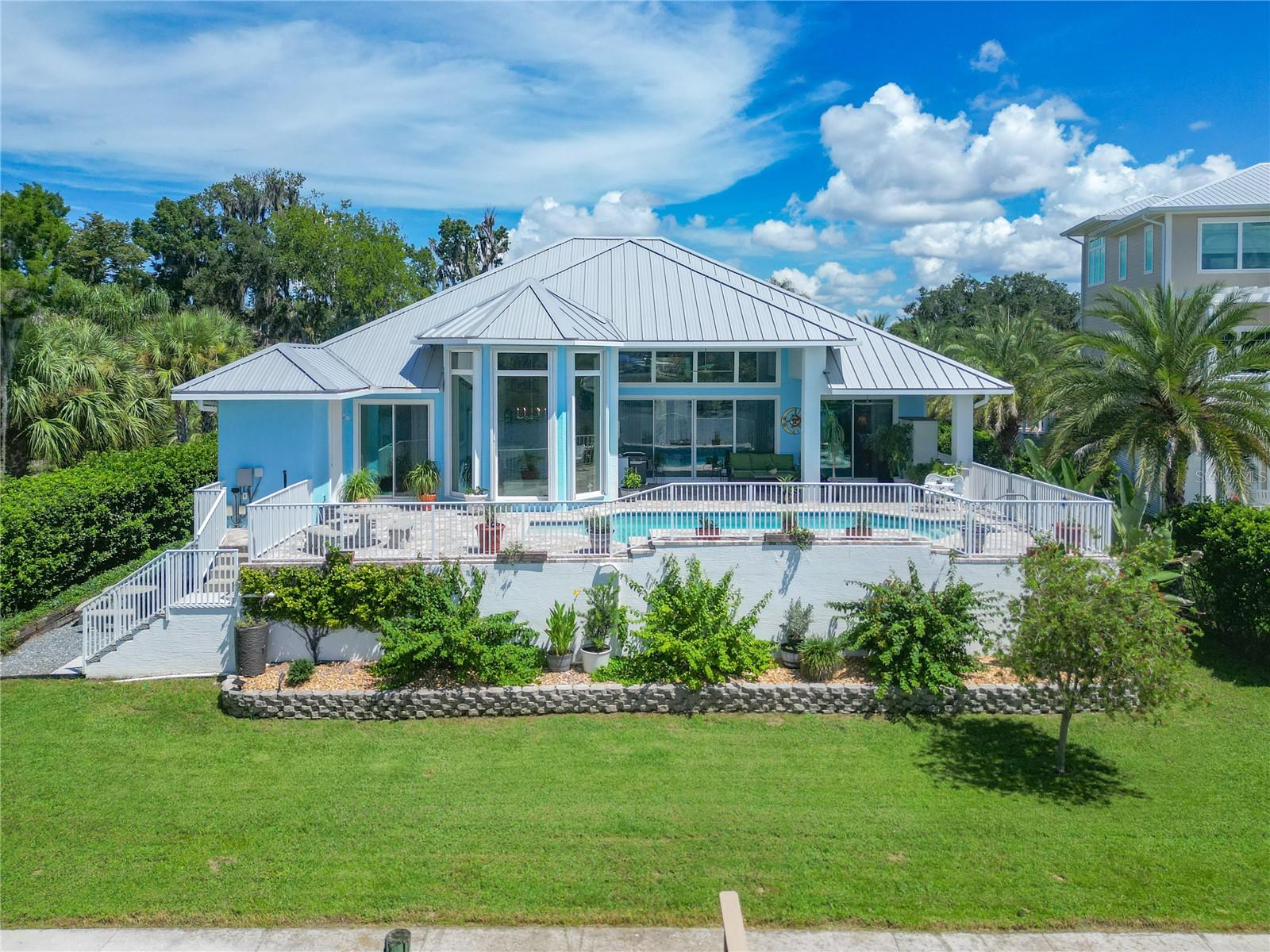 Welcome to waterfront living on one of Crystal River's most sought-after streets—Kings Bay Drive! Built in 2021 and offering over 2,400 square feet of thoughtfully designed living space, this exceptional home captures breathtaking panoramic views of Kings Bay while blending luxury, comfort, and the laid-back Nature Coast lifestyle. Designed to maximize both space and scenery, the flexible floor plan offers four bedrooms or three bedrooms plus a versatile flex room to fit your needs. High ceilings, oversized doors, elegant tray ceilings, and walls of windows fill the home with natural light, while French-style sliding glass doors seamlessly connect the living area to the expansive lanai, sparkling pool, and incredible waterfront backdrop. The spacious primary suite is a true retreat, featuring direct access to the pool and patio, dual walk-in closets, separate vanities, a jetted soaking tub, and an oversized walk-in shower. A second private primary suite with its own pool access provides the perfect setup for guests or multi-generational living. Storage is abundant throughout the home, including two oversized pantries and ample closet space. Outside, the paver driveway, walkways, and pool deck create beautiful curb appeal while extending the home's elegant finishes outdoors. Built high and dry, this property offers peace of mind along with an unbeatable location in Crystal River's popular golf cart community. Spend your days boating to waterfront restaurants, festivals, and local attractions, or explore the crystal-clear waters of Kings Spring, Hunter Springs, and the world-famous Three Sisters Springs—all just minutes away. Surrounded by abundant wildlife and stunning waterfront views, this is more than a home—it's the Florida lifestyle you've been dreaming of.